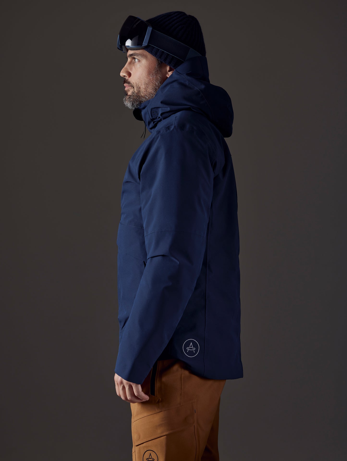 Side profile body view of man wearing Silverton Down Jacket in Total Eclipse dark blue from AETHER Apparel.
