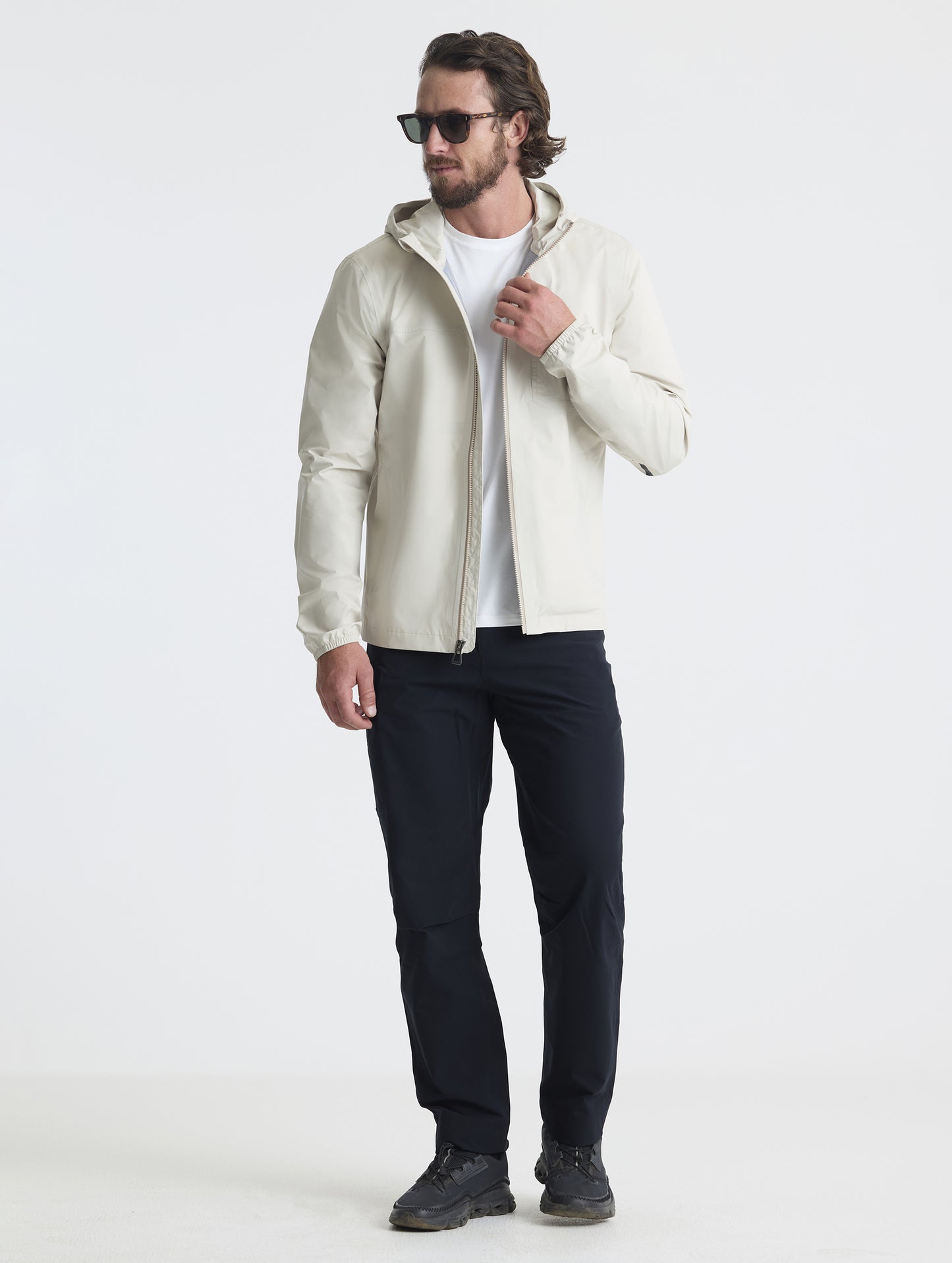 Full body view of man wearing Storm All-Weather Jacket in Bone white from AETHER Apparel.