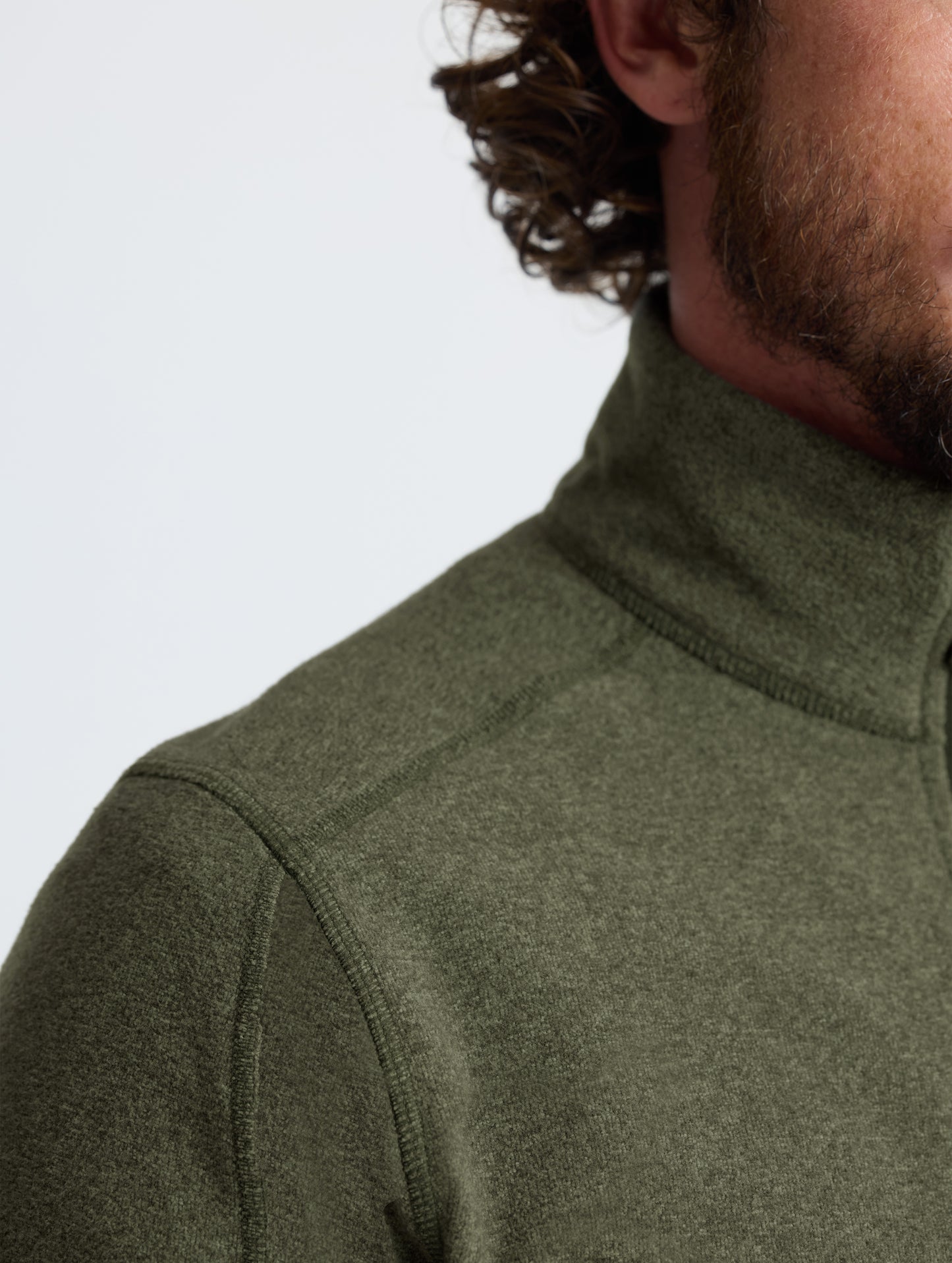 Closeup view of wearer's right shoulder of Sutherlin Half-Zip in Forest Green from AETHER Apparel.