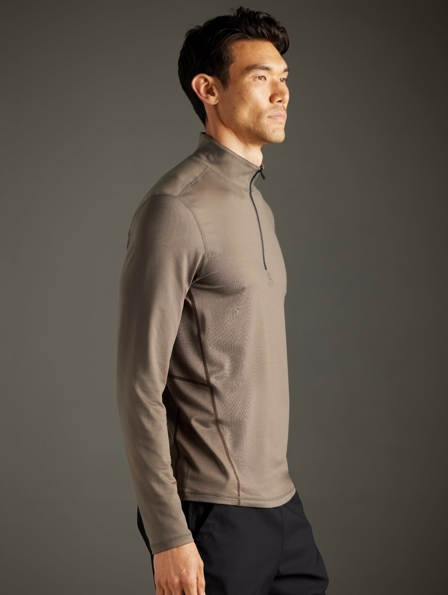 Side profile body view of man wearing Trek Articulated Half-Zip Tee in Cadet Green from AETHER Apparel.