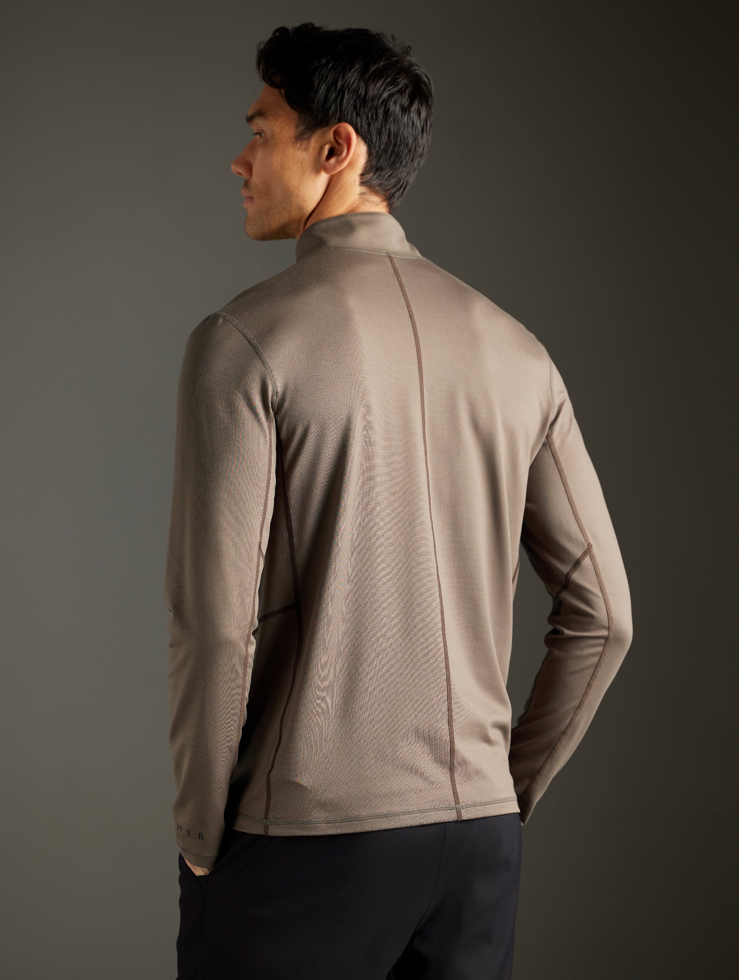 Rear 3/4 body view of man wearing Trek Articulated Half-Zip Tee in Cadet Green from AETHER Apparel.