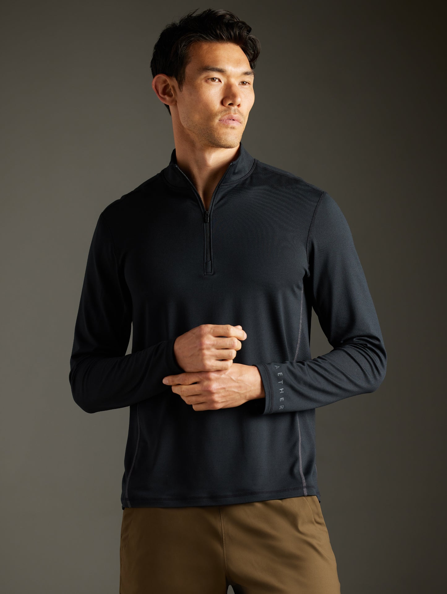 Front body view of man wearing Trek Articulated Half-Zip Tee in Onyx Black from AETHER Apparel.