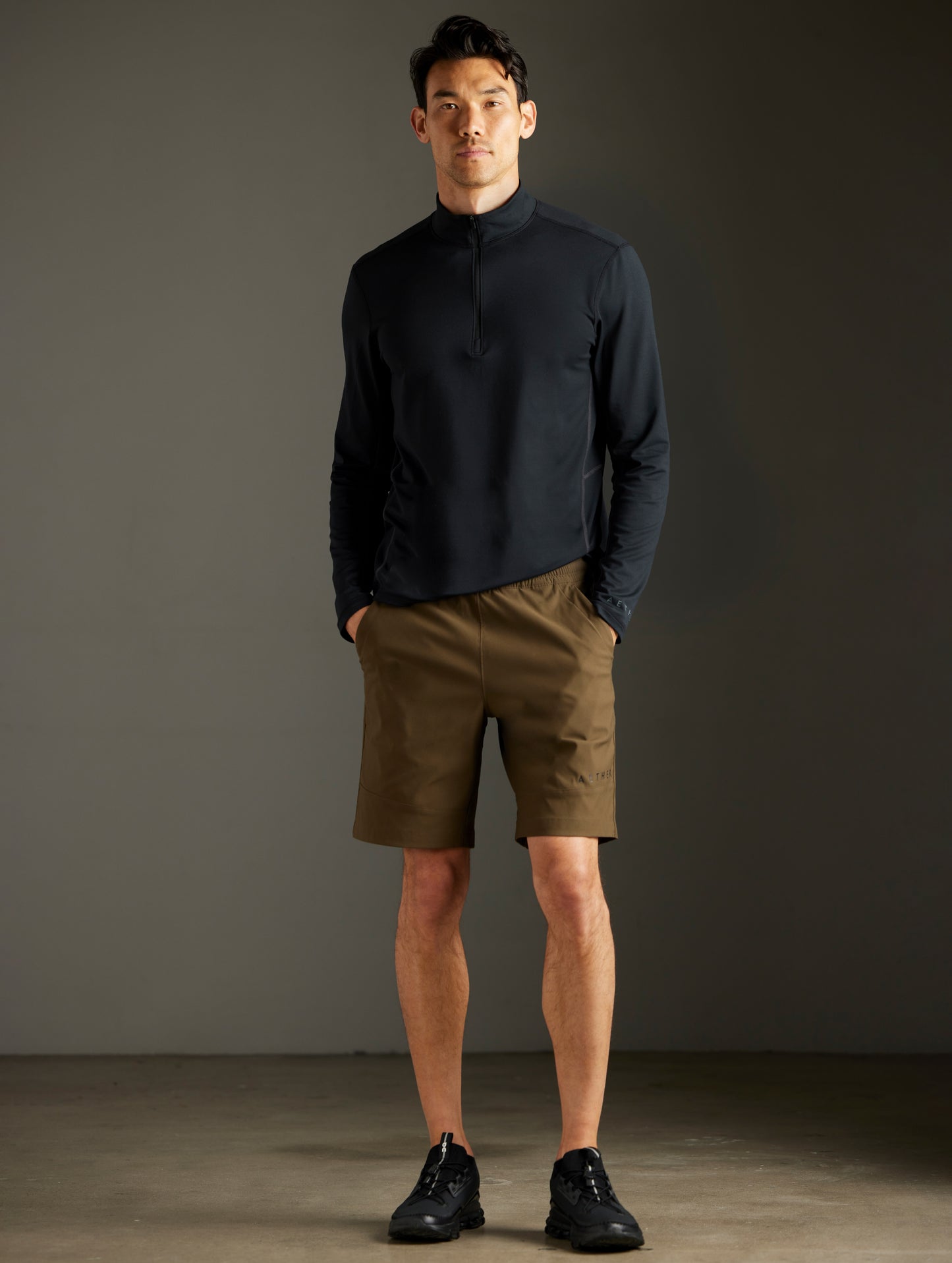 Front full-body view of man wearing Trek Articulated Half-Zip Tee in Onyx Black from AETHER Apparel.