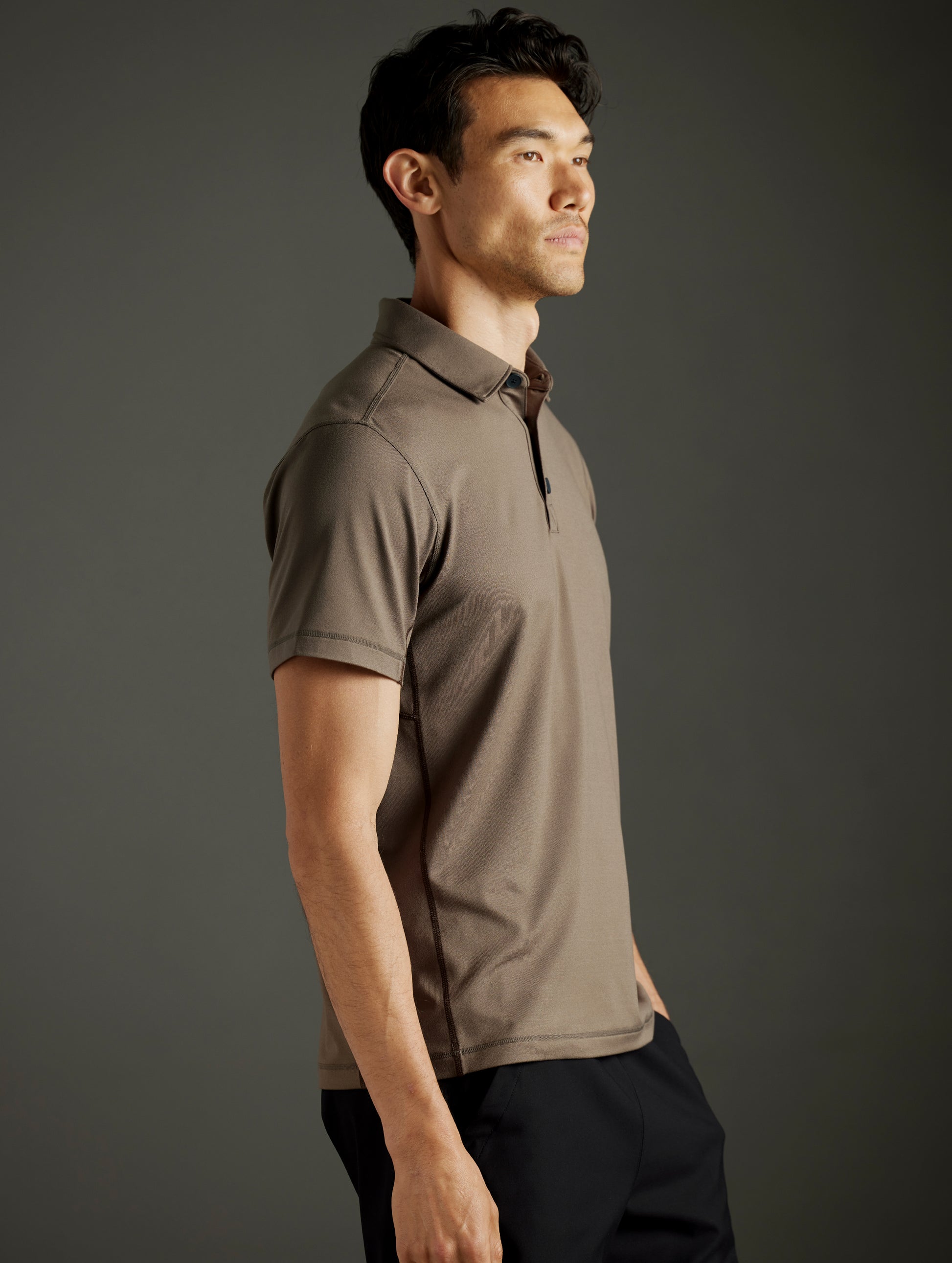 Side profile body view of man wearing Trek Articulated Polo in Cadet Green from AETHER Apparel.