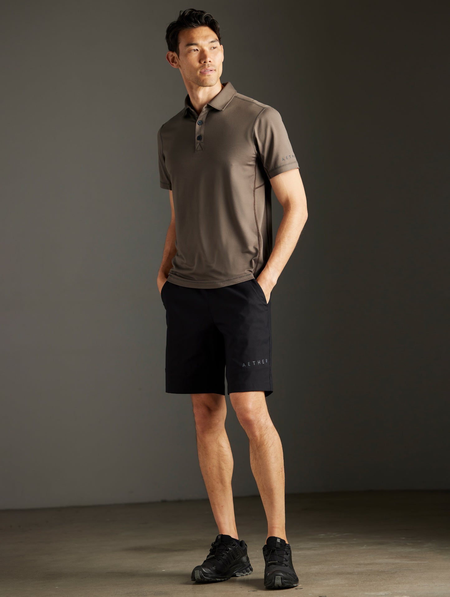 Front 3/4 full-body view of man wearing Trek Articulated Polo in Cadet Green from AETHER Apparel.