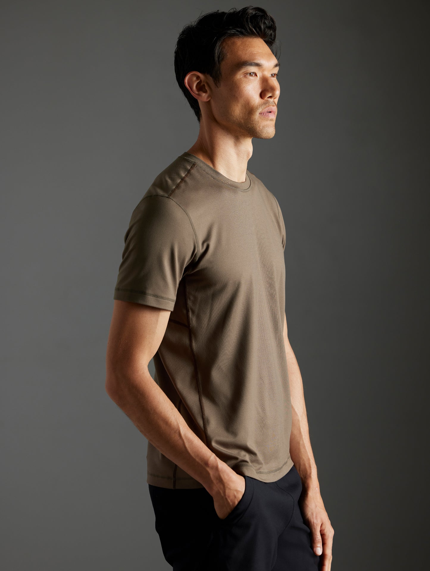 Front 3/4 body view of man wearing Trek Articulated Tee in Cadet green from AETHER Apparel.