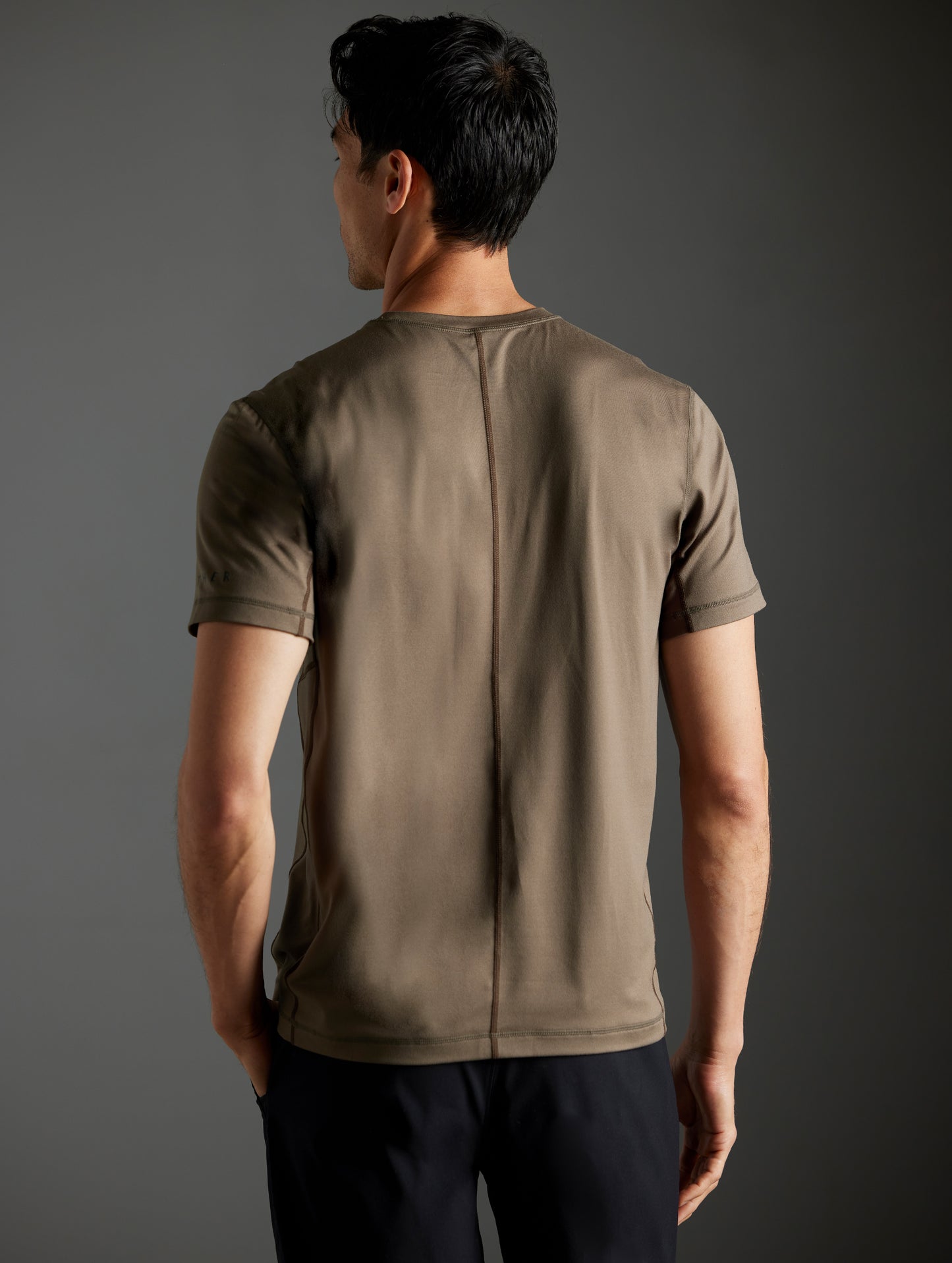 Rear body view of man wearing Trek Articulated Tee in Cadet green from AETHER Apparel.