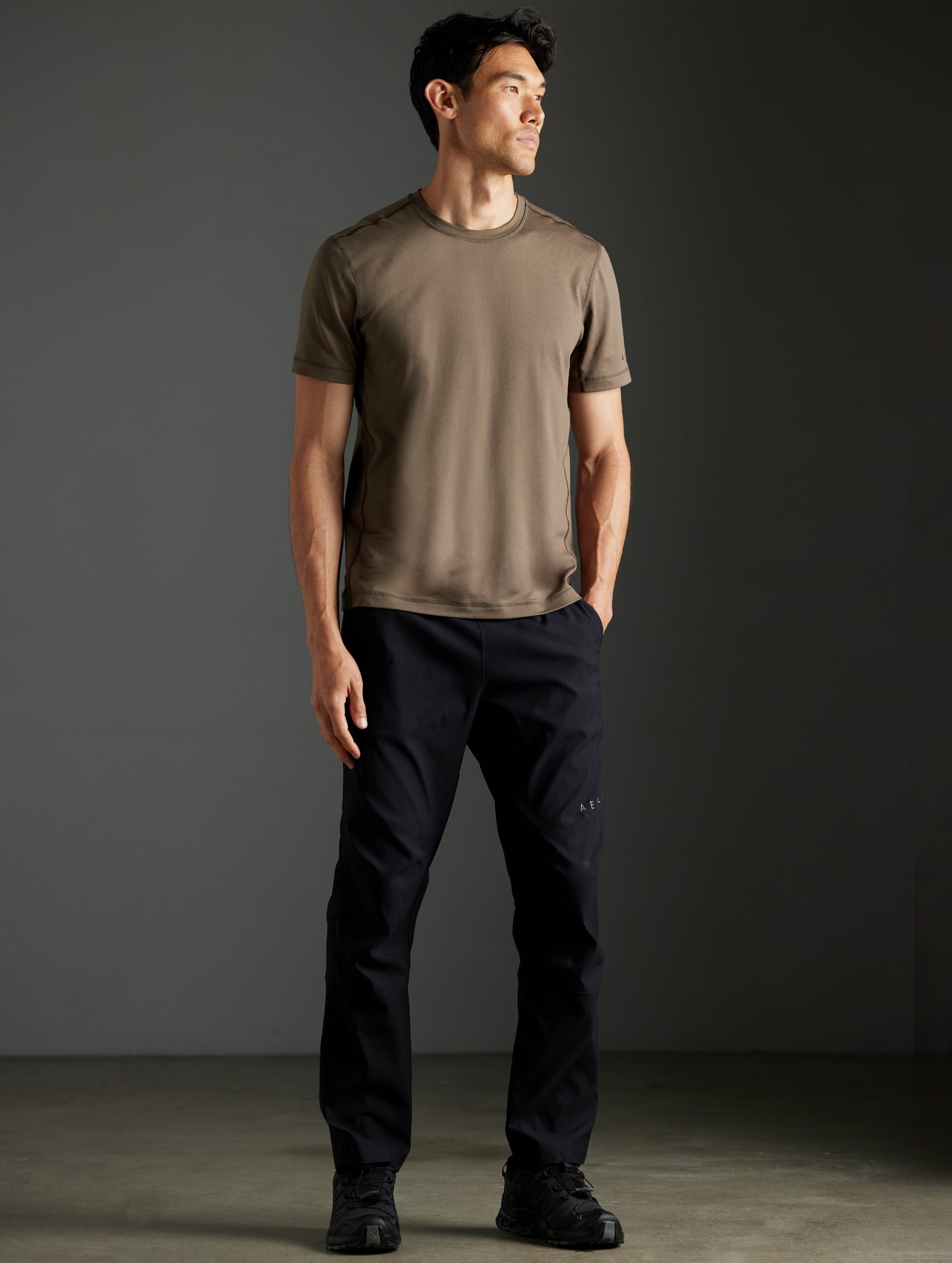 Front full-body view of man wearing Trek Articulated Tee in Cadet green from AETHER Apparel.