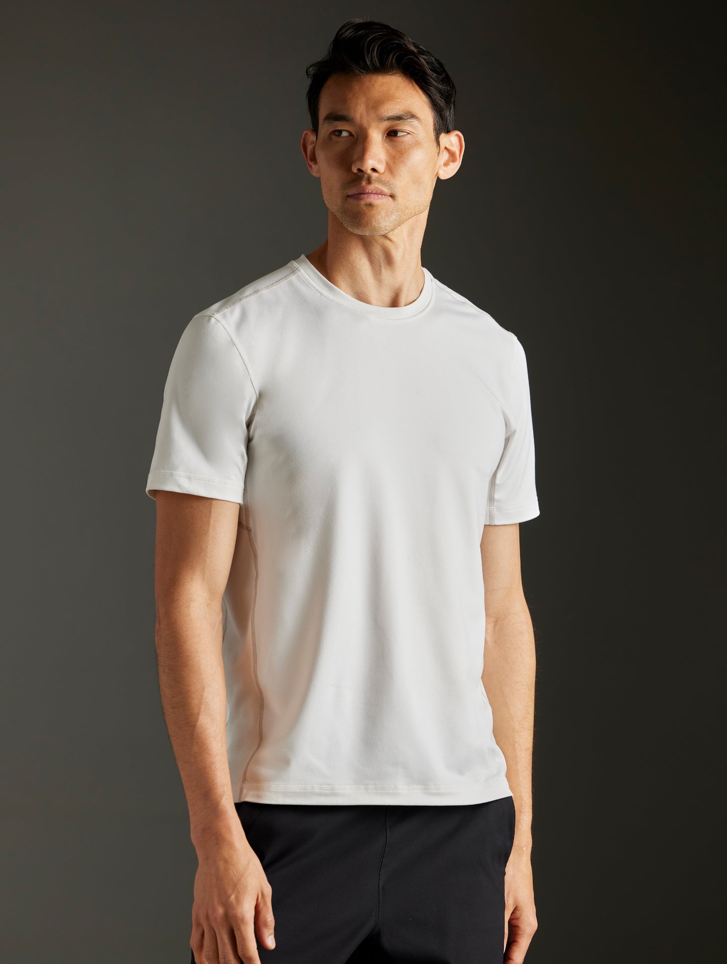 Front 3/4 body view of man wearing Trek Articulated Tee in Natural White from AETHER Apparel.