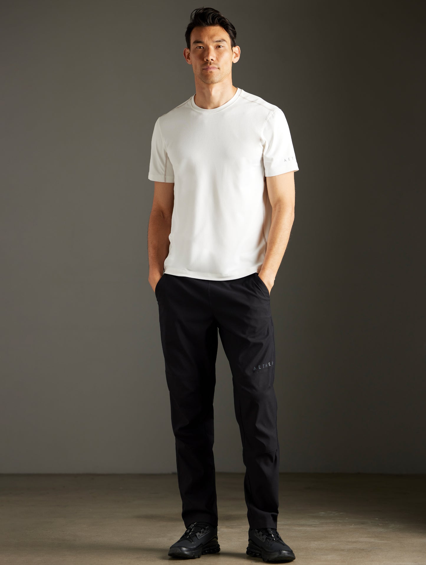 Front full-body view of man wearing Trek Articulated Tee in Natural White from AETHER Apparel.