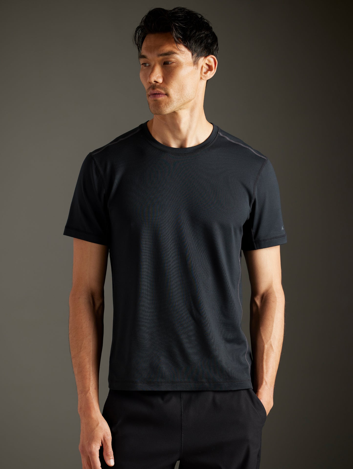 Front body view of man wearing Trek Articulated Tee in Onyx Black from AETHER Apparel.