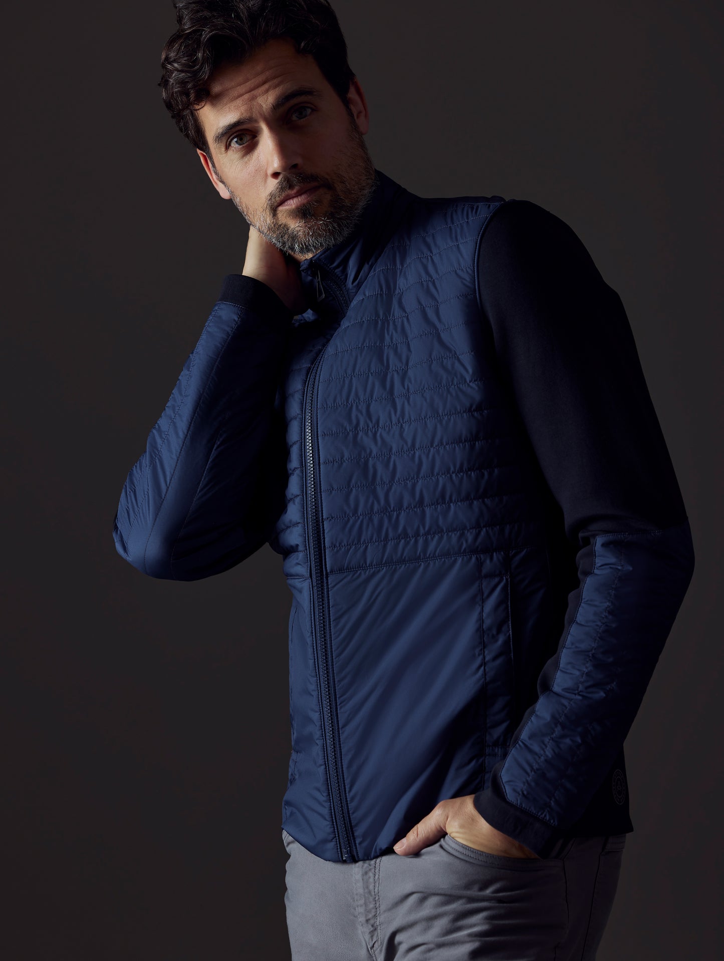 Front 3/4 body view of man wearing Watts Technical Jacket in Total Eclipse dark blue from AETHER Apparel.