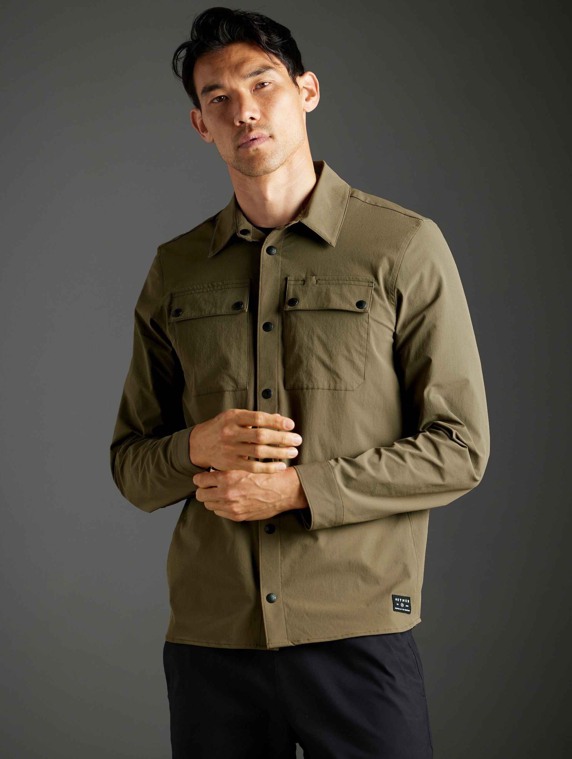 Front 3/4 body view of man wearing Wonder Technical Button-Down in Cadet green from AETHER Apparel.
