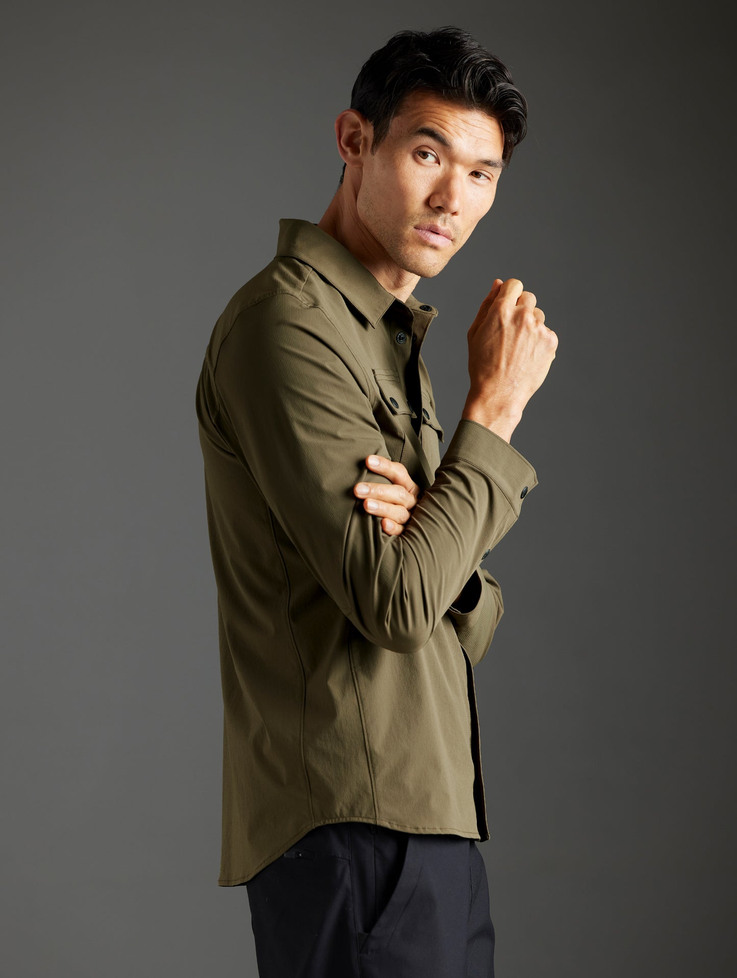 Side profile body view of man wearing Wonder Technical Button-Down in Cadet green from AETHER Apparel.