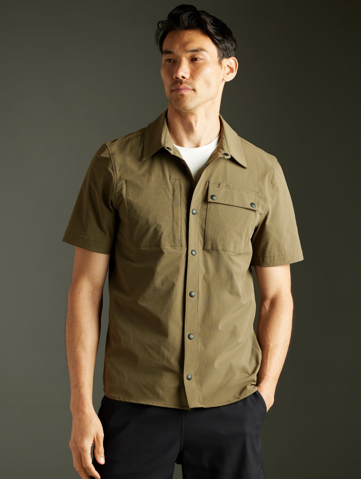 Front body view of man wearing Wonder Technical Short-Sleeve Button-Down in Cadet green from AETHER Apparel.