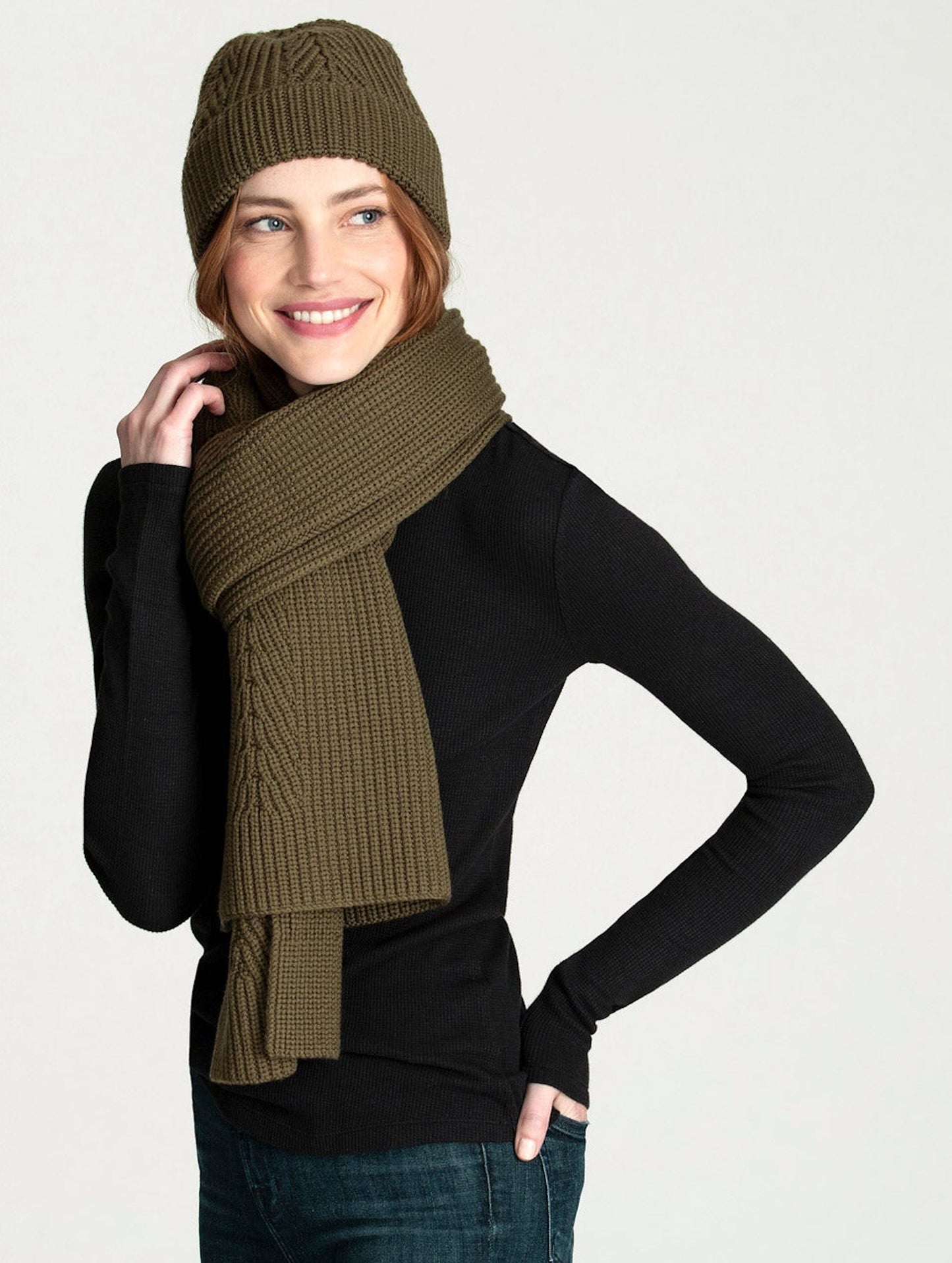 Angled view of woman wearing green Peak Scarf from AETHER Apparel and matching beanie.