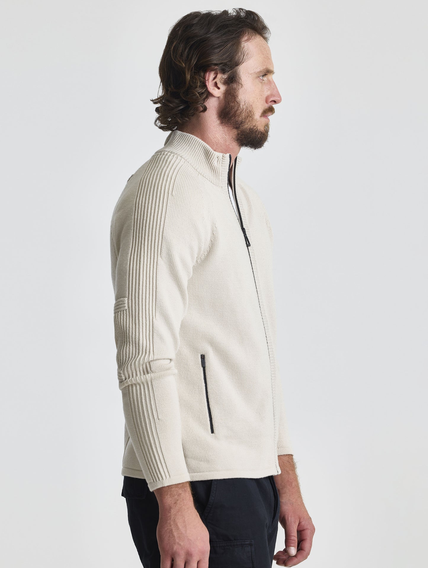 Right profile view of man wearing Riley Full-Zip Sweater in Bone white from AETHER Apparel.