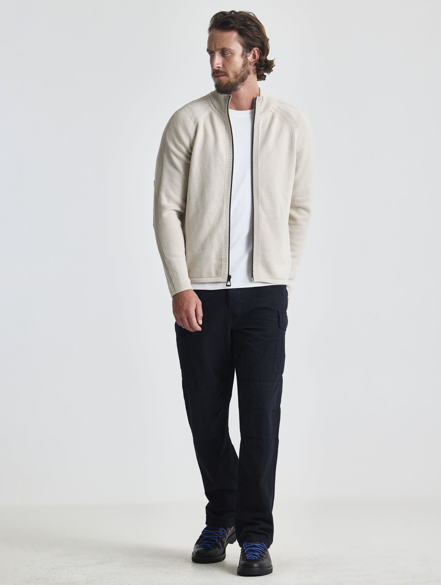 Full body view of man wearing Riley Full-Zip Sweater in Bone white from AETHER Apparel.