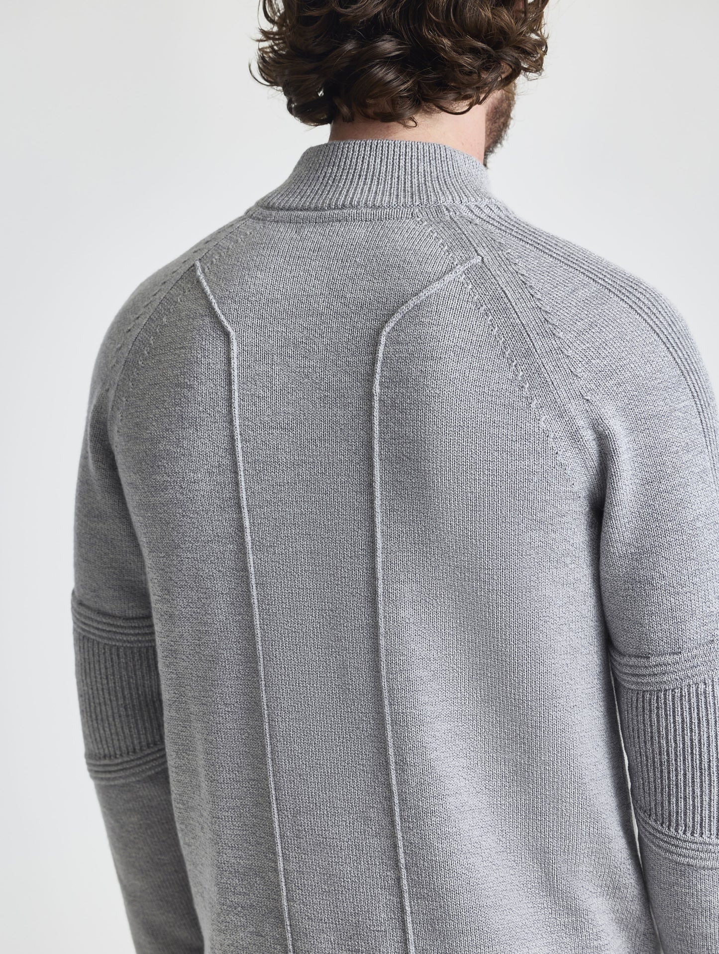 Closeup detail view of stitching on back of Riley Full-Zip Sweater in Heather Grey from AETHER Apparel.