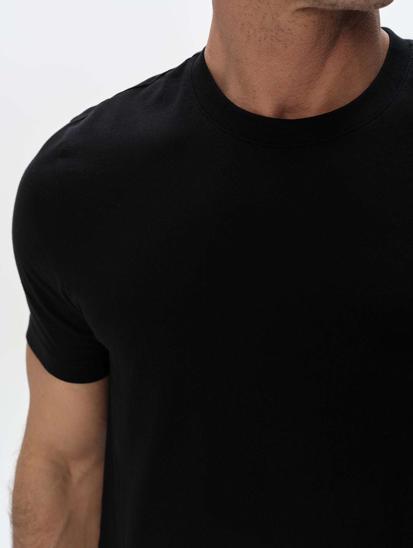 Closeup detailed view of the shoulder and patch pocket on the Standard Tee in Onyx Black from AETHER Apparel.
