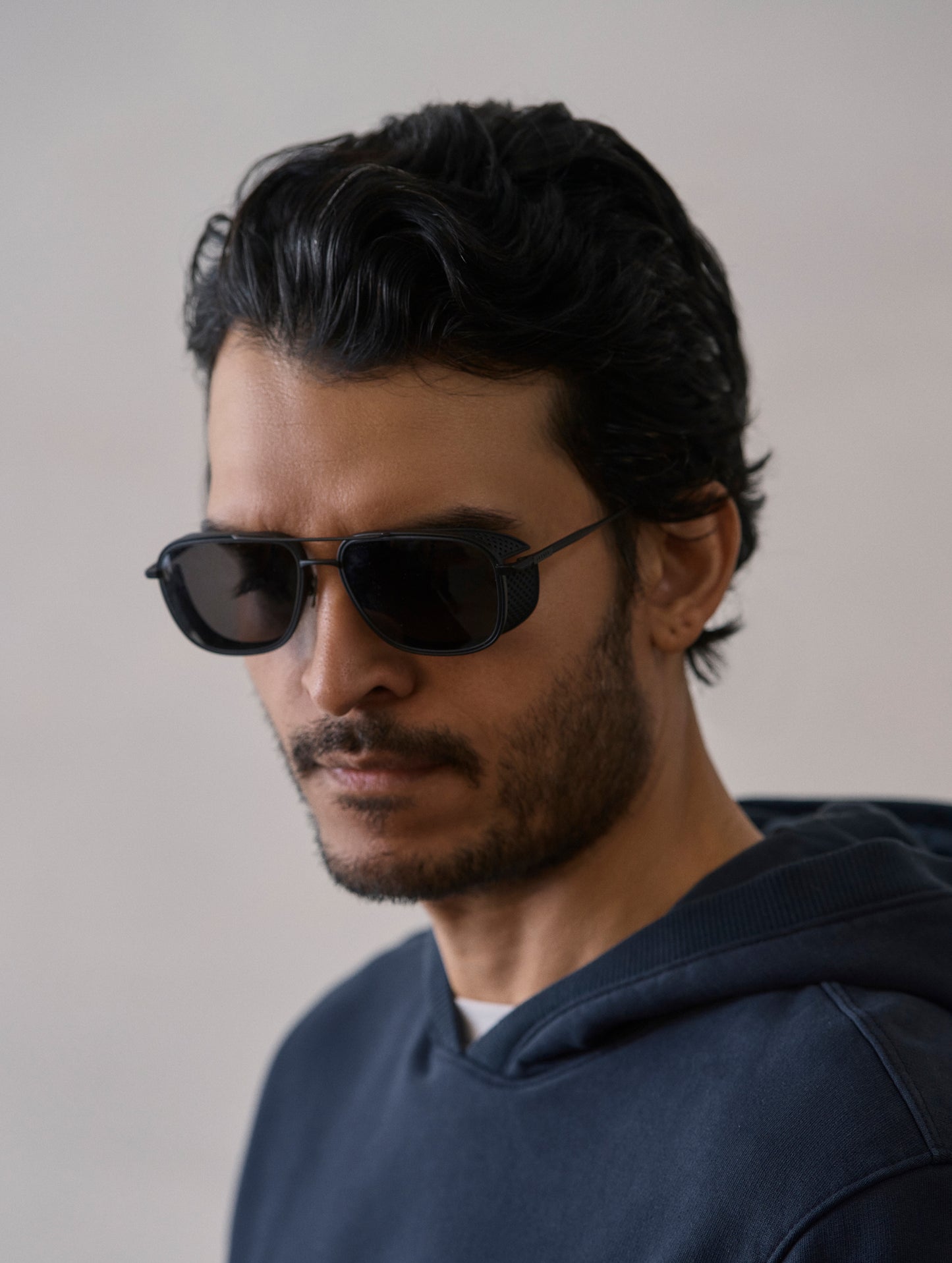 Front 3/4 view of man wearing Summit Sunglass in Black titanium with black lens from AETHER Apparel.
