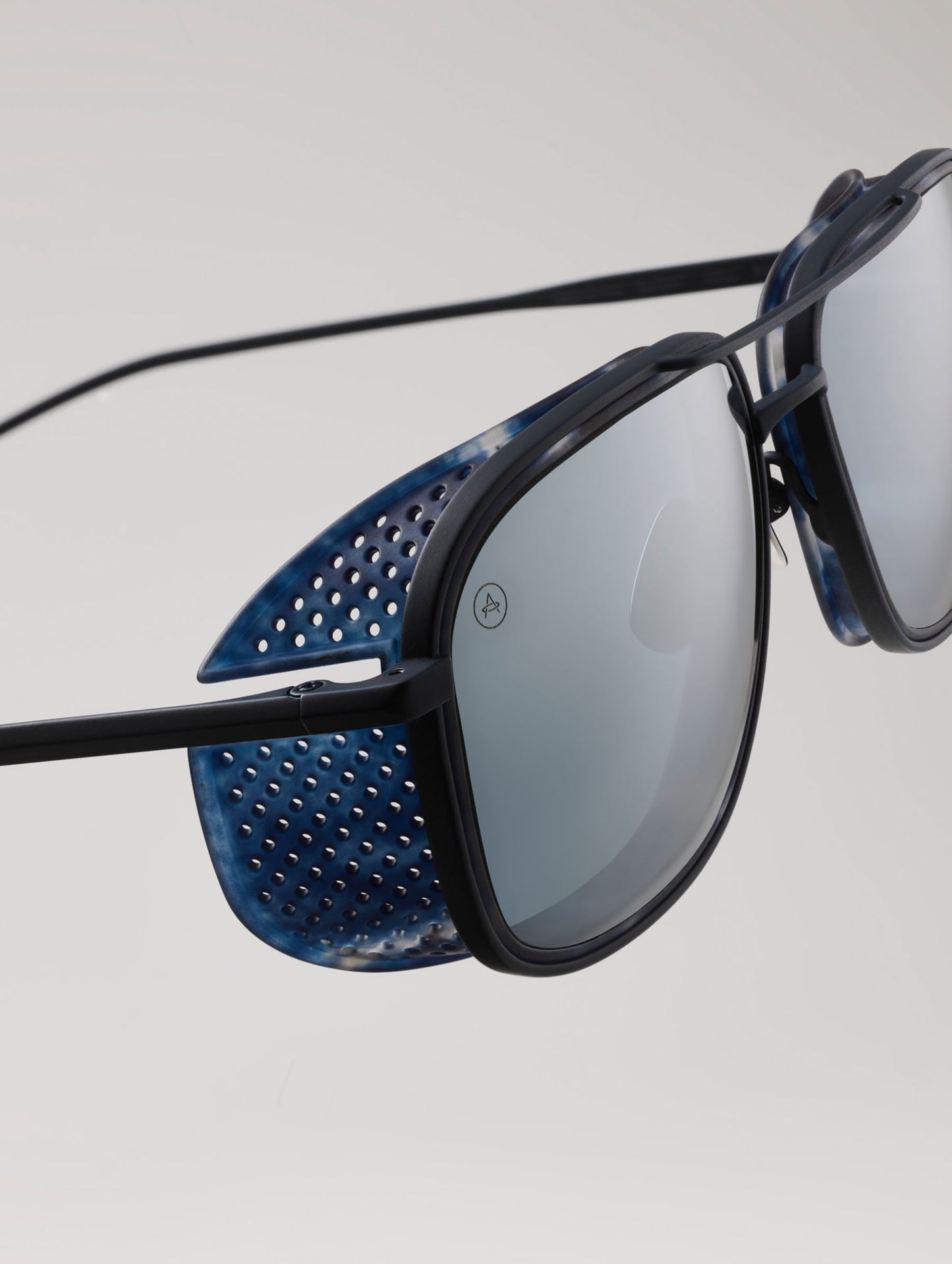 Closeup detail image of perforated side shields on Summit Sunglass in Blue titanium with Blue Lens from AETHER Apparel.