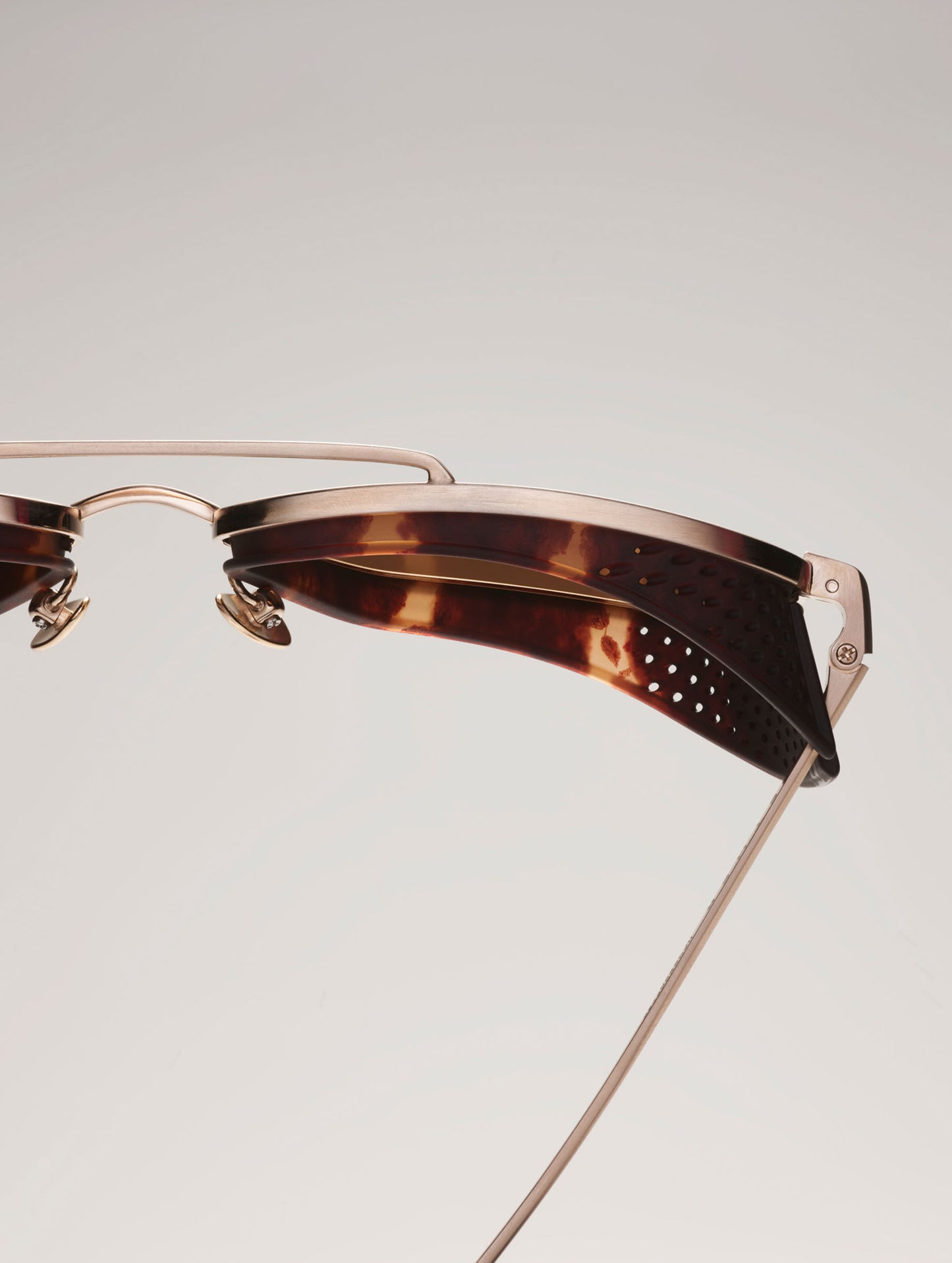 Closeup top-down detail image of Summit Sunglass in Brushed Gold titanium with G15 Lens from AETHER Apparel.