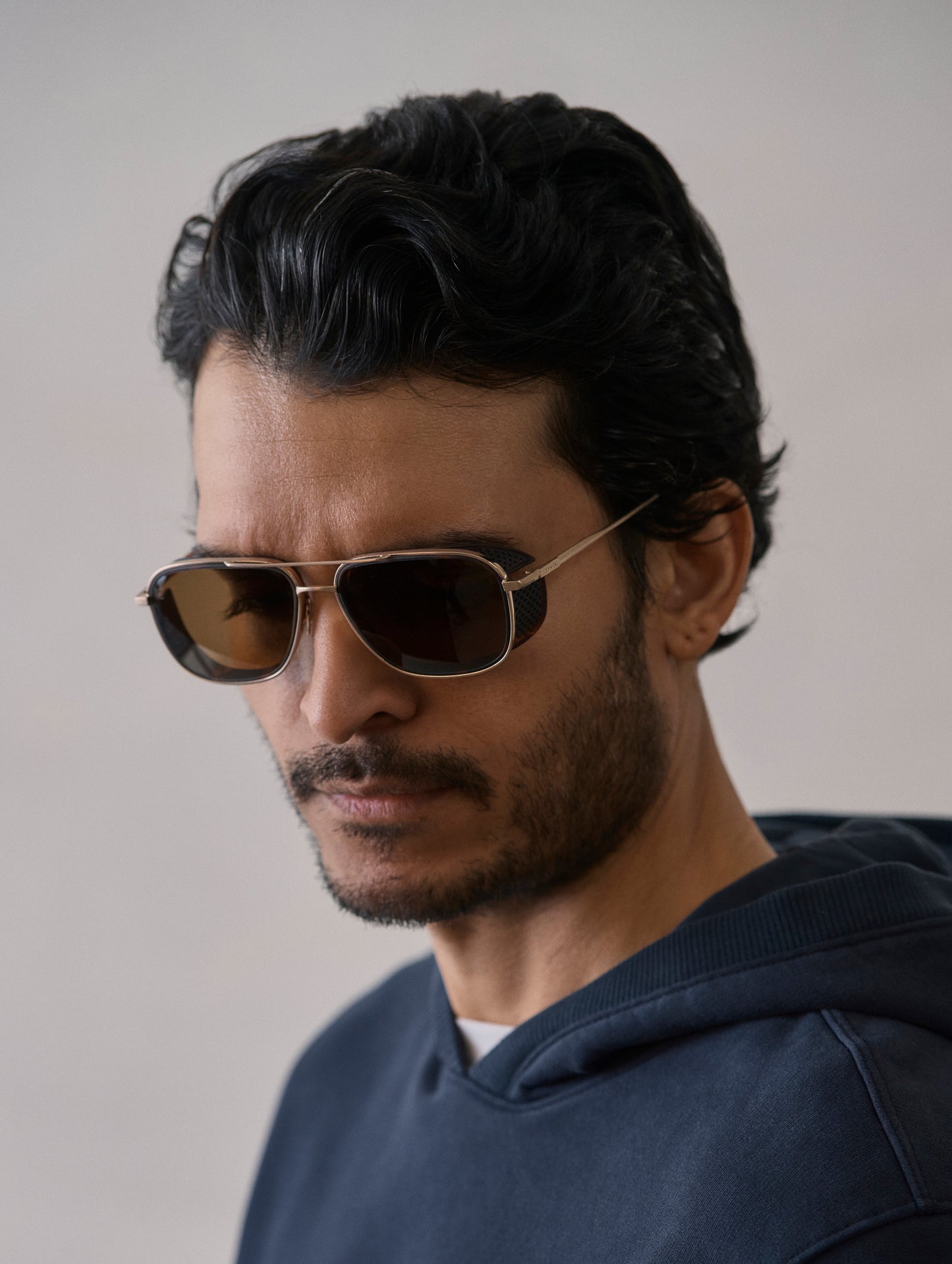 Front 3/4 view of man wearing Summit Sunglass in Brushed Gold titanium with G15 Lens from AETHER Apparel.