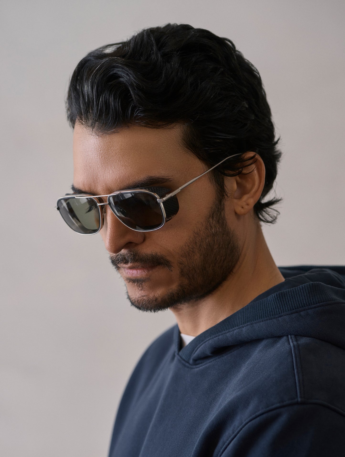 Front 3/4 view of man wearing Summit Sunglass in Brushed Silver titanium with Grey Lens from AETHER Apparel.