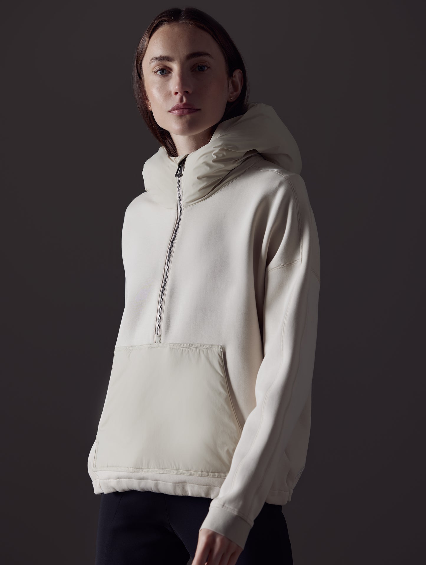 Front angled view of woman wearing Align Hooded Anorak in Bone white from AETHER Apparel.
