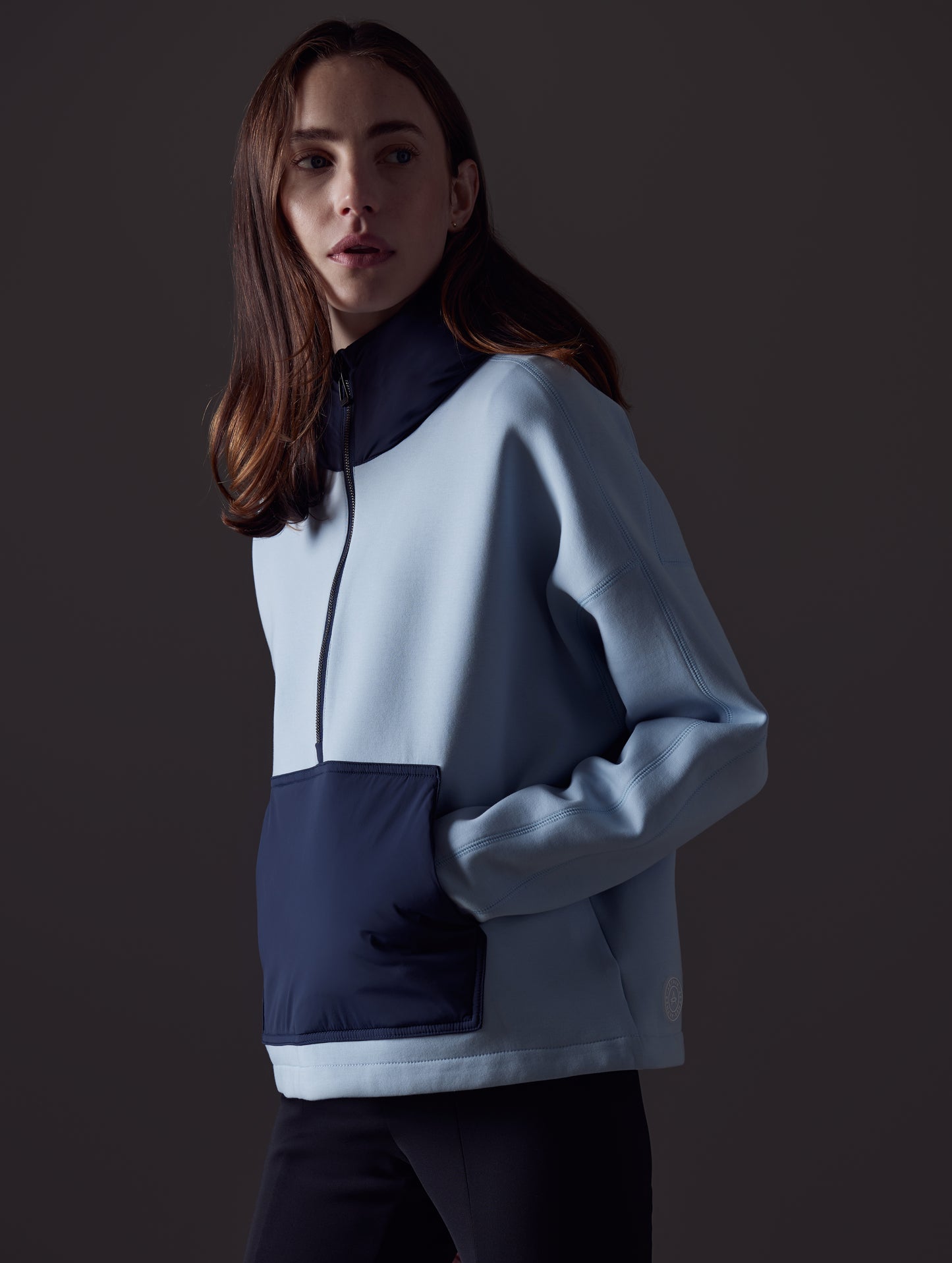 Front angled view of woman wearing Align Hooded Anorak in Flight Blue from AETHER Apparel.
