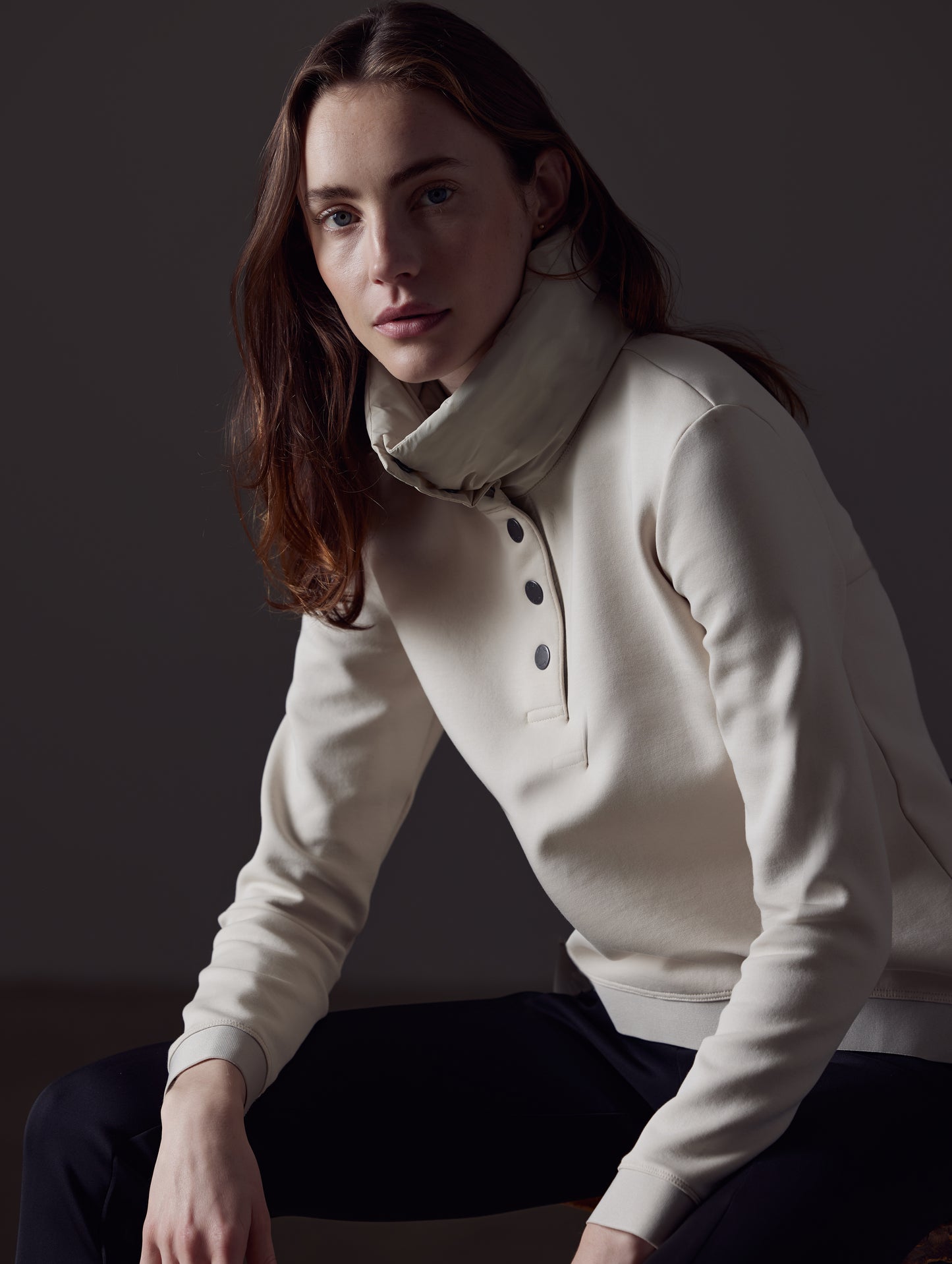 Front angled view of woman sitting wearing Align Pullover in Bone white from AETHER Apparel.