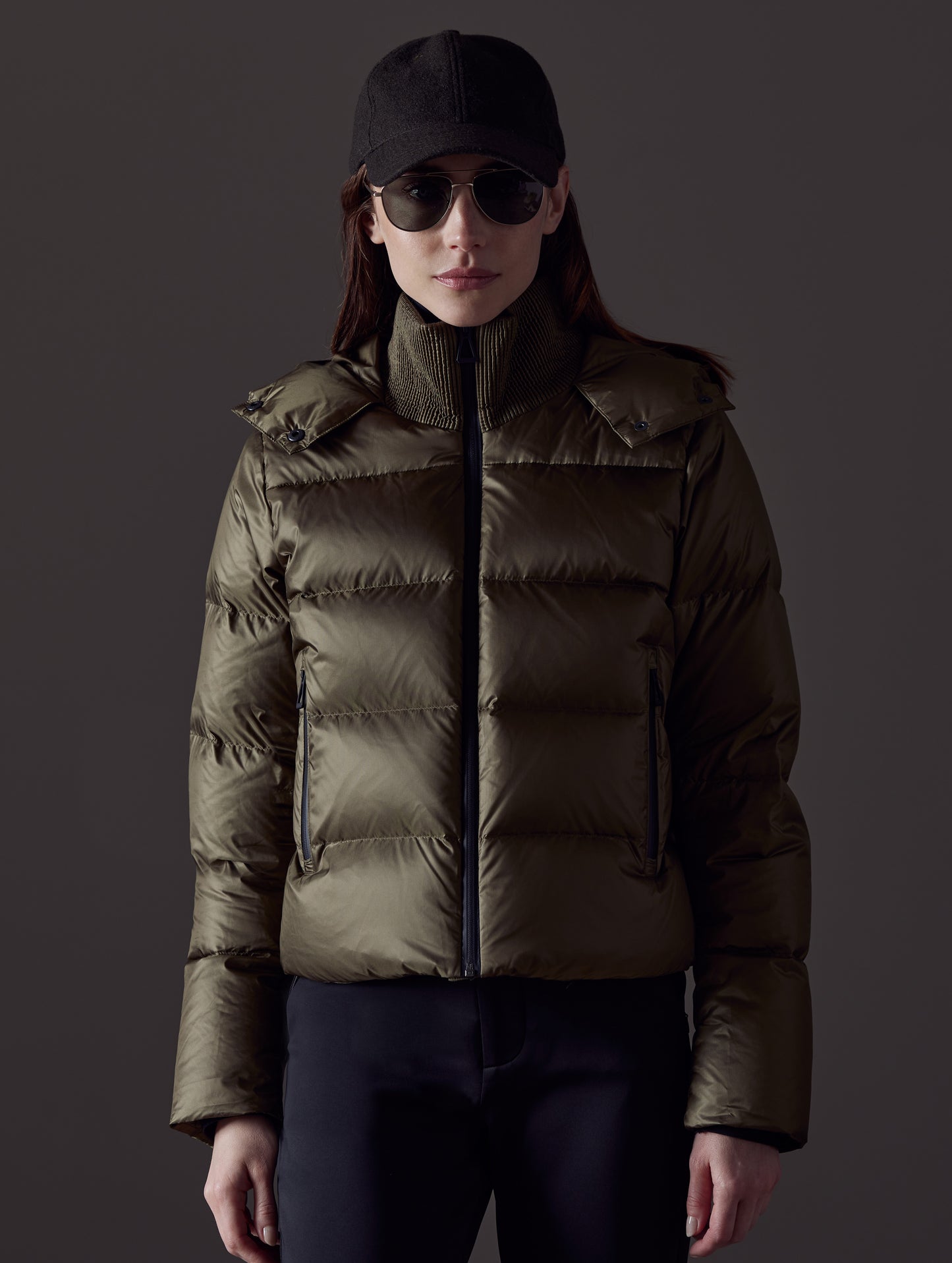 Front body view of woman wearing Aura Puffer Jacket in Command Green from AETHER Apparel.