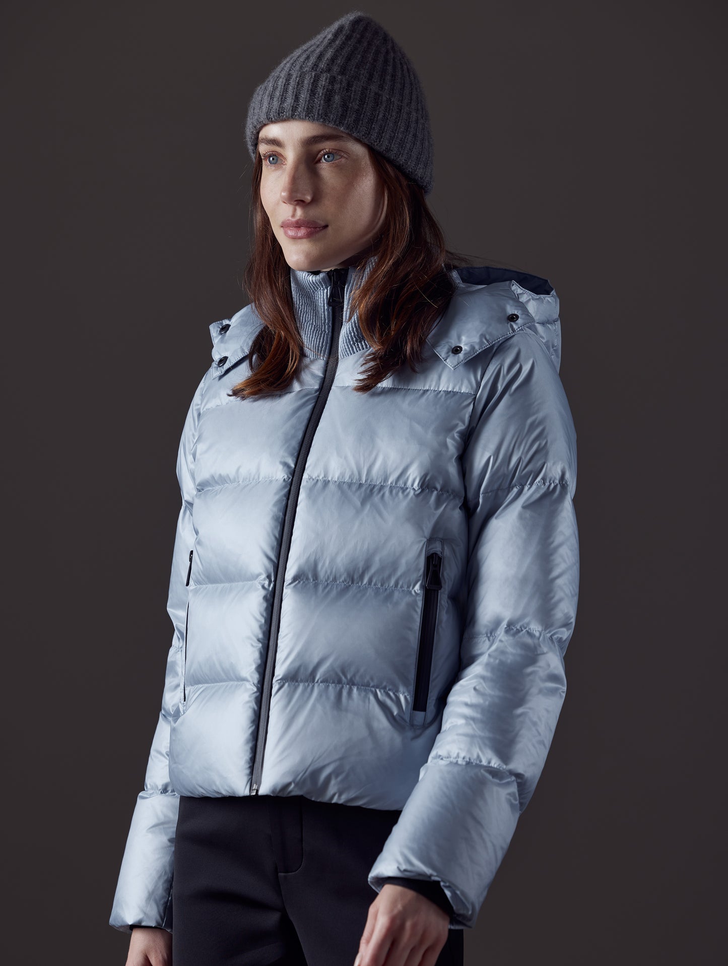 Front angled view of woman wearing Aura Puffer Jacket in Flight Blue from AETHER Apparel.