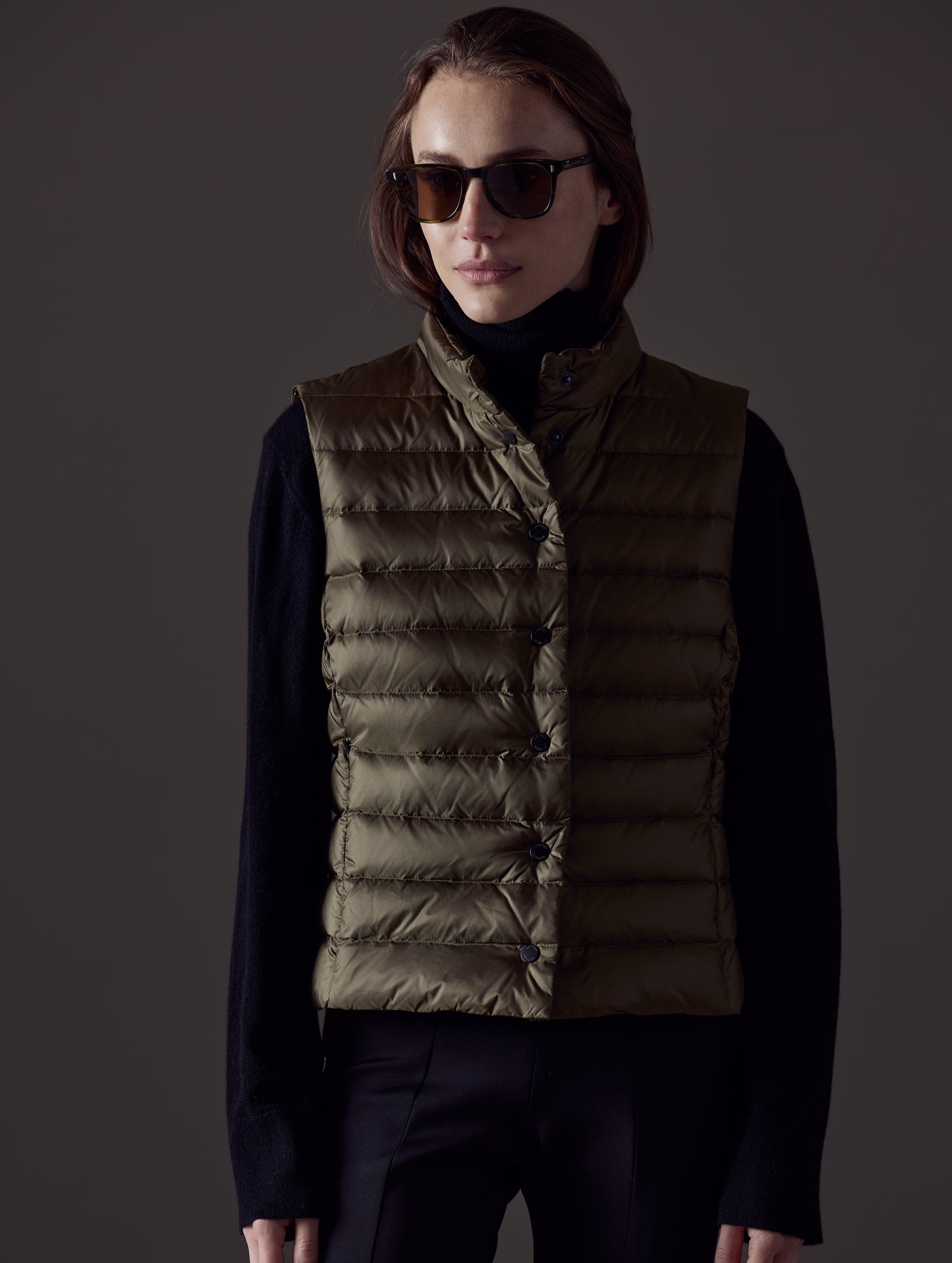 Front body view of woman wearing Aura Vest in Command Green from AETHER Apparel.