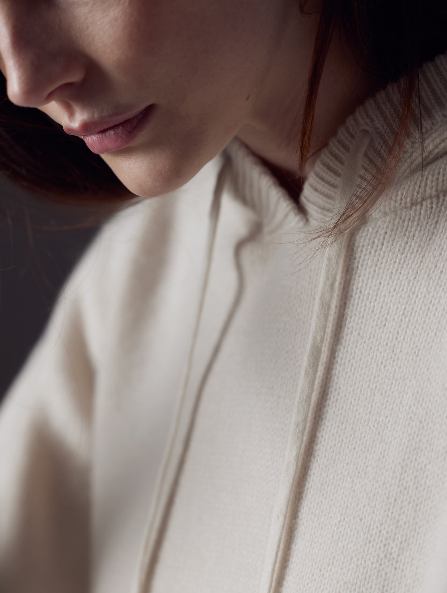 Closeup detailed view of drawstrings, knitted collar, and Cashmere construction of women's Ava Cashmere Hooded Sweater in Winter White from AETHER Apparel.