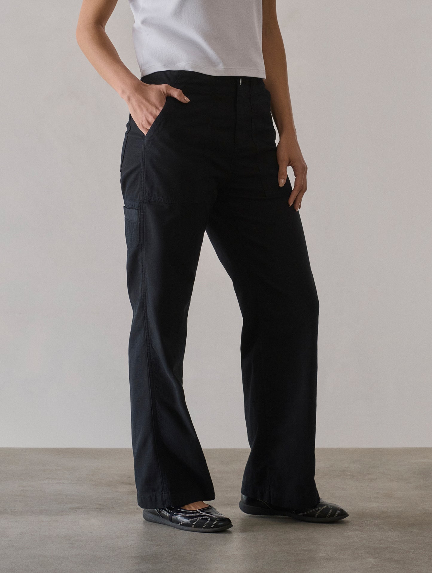 Front 3/4 lower body view of woman wearing Bella Travel Pant in Onyx Black from AETHER Apparel.