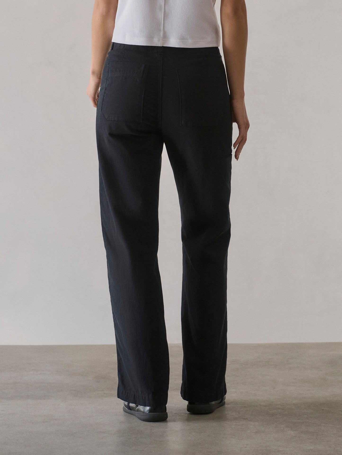 Rear lower body view of woman wearing Bella Travel Pant in Onyx Black from AETHER Apparel.