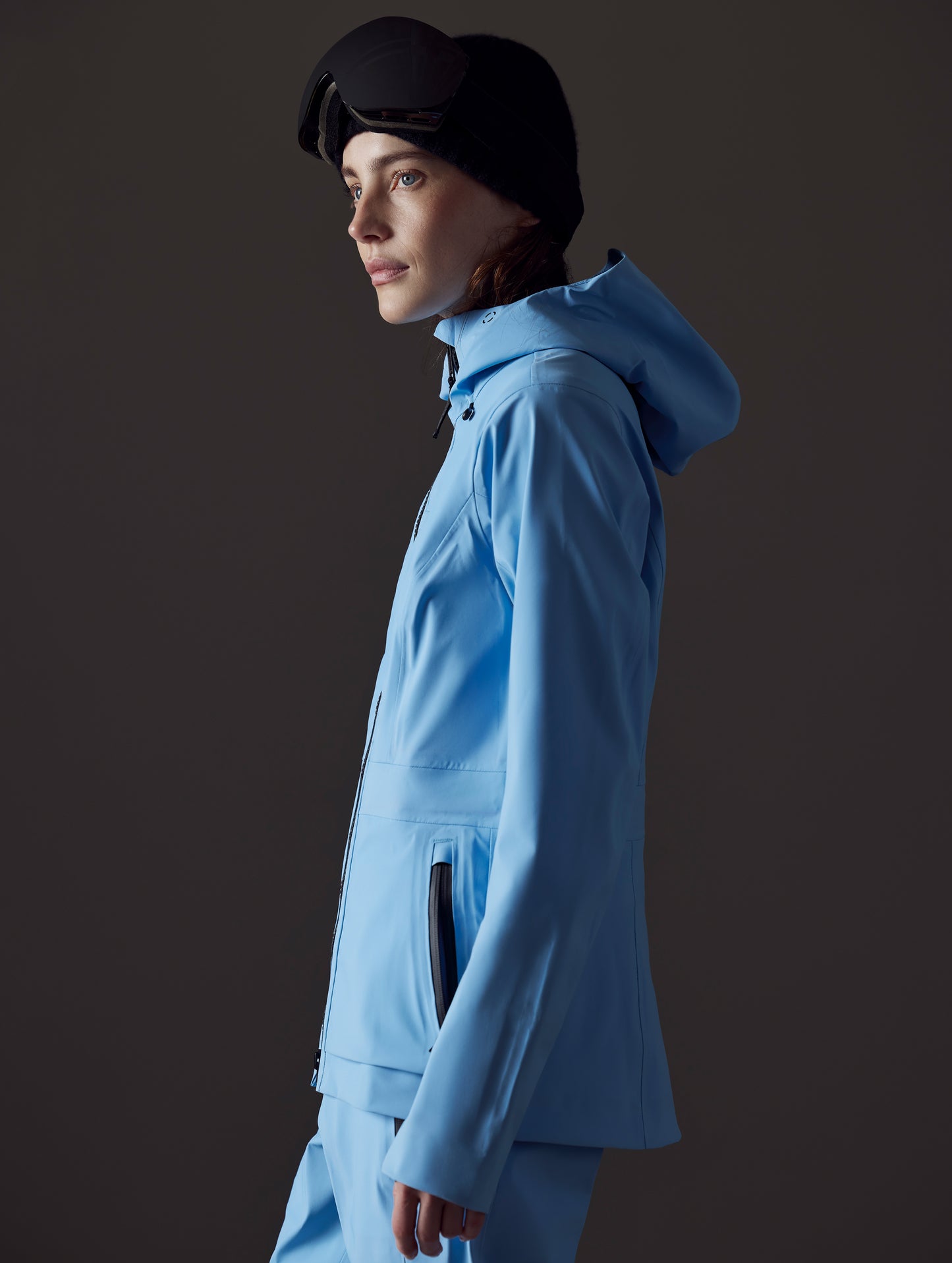 Side profile view of woman wearing Boyd Snow Jacket in Atlas Blue from AETHER Apparel.