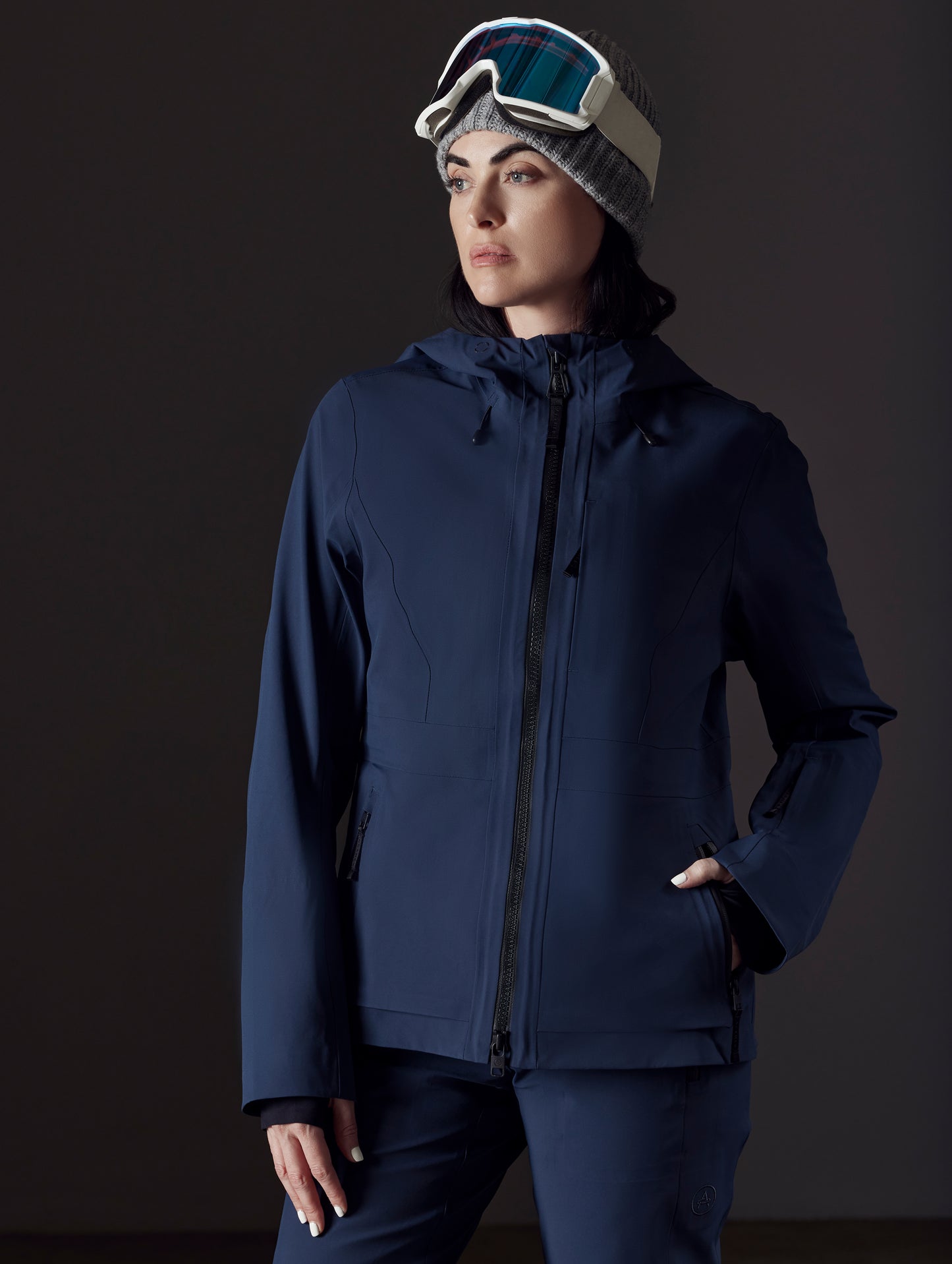 Front right angled view of woman wearing Boyd Snow Jacket in Total Eclipse dark blue from AETHER Apparel.