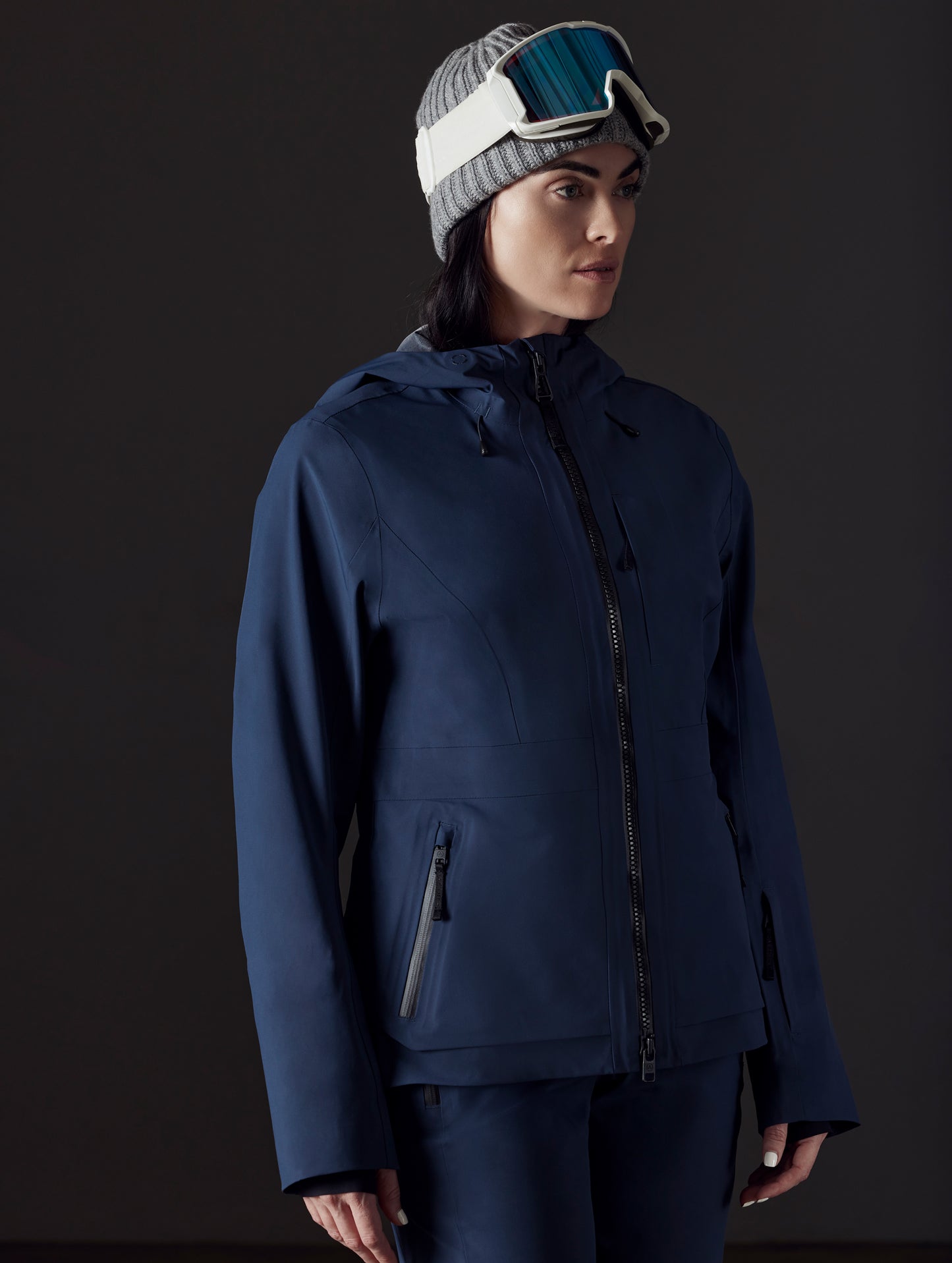 Front left angled view of woman wearing Boyd Snow Jacket in Total Eclipse dark blue from AETHER Apparel.
