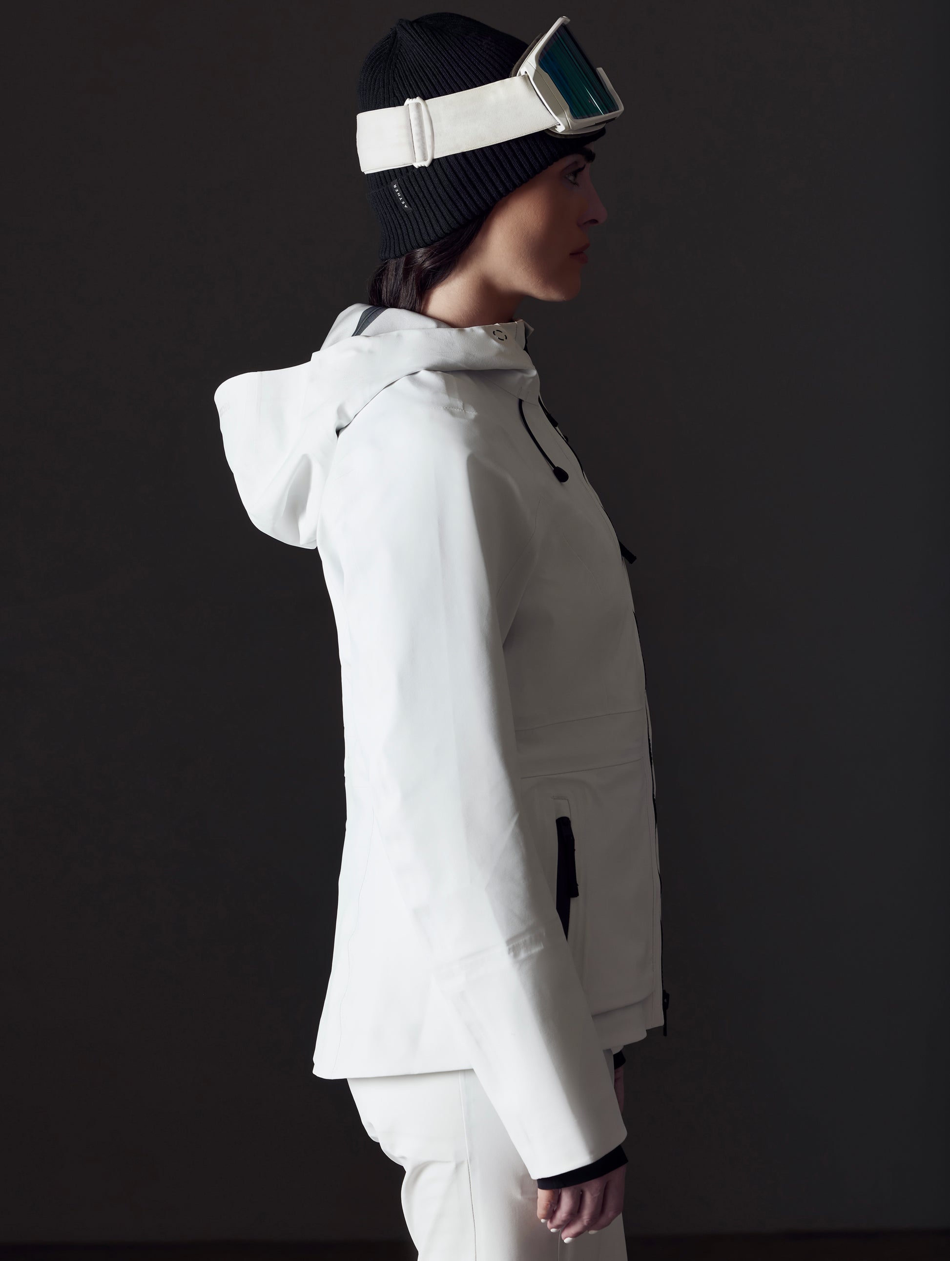 Side profile view of woman wearing Boyd Snow Jacket in White from AETHER Apparel.