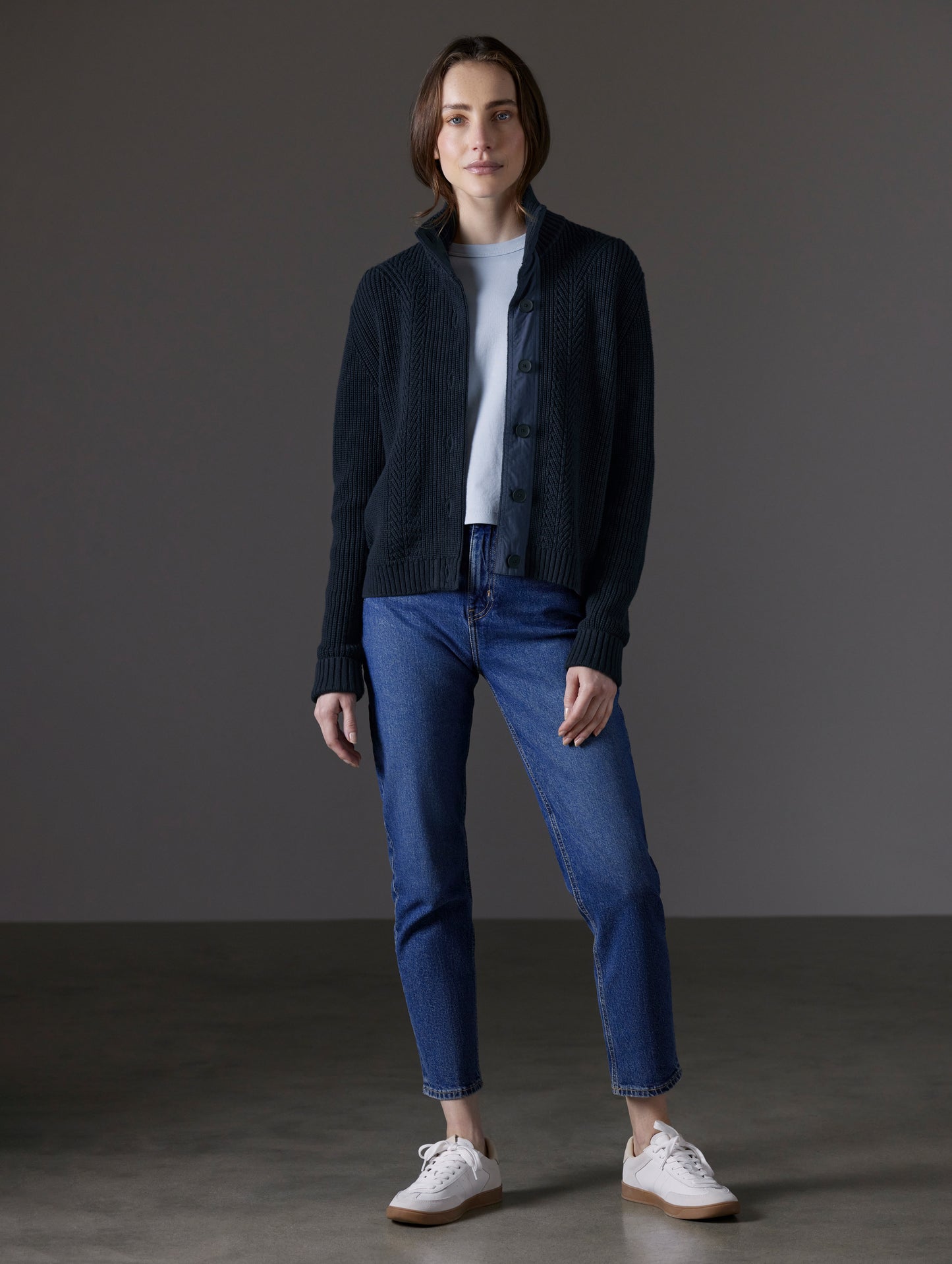 Front full-body view of woman wearing unbuttoned Cato Buttoned Sweater in Total Eclipse dark blue from AETHER Apparel.