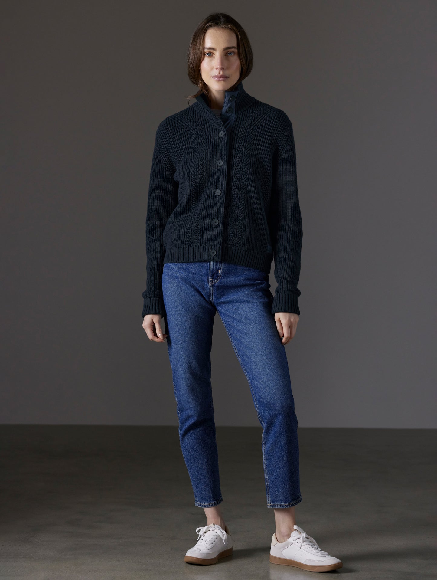 Front full-body view of woman wearing buttoned-up Cato Buttoned Sweater in Total Eclipse dark blue from AETHER Apparel.