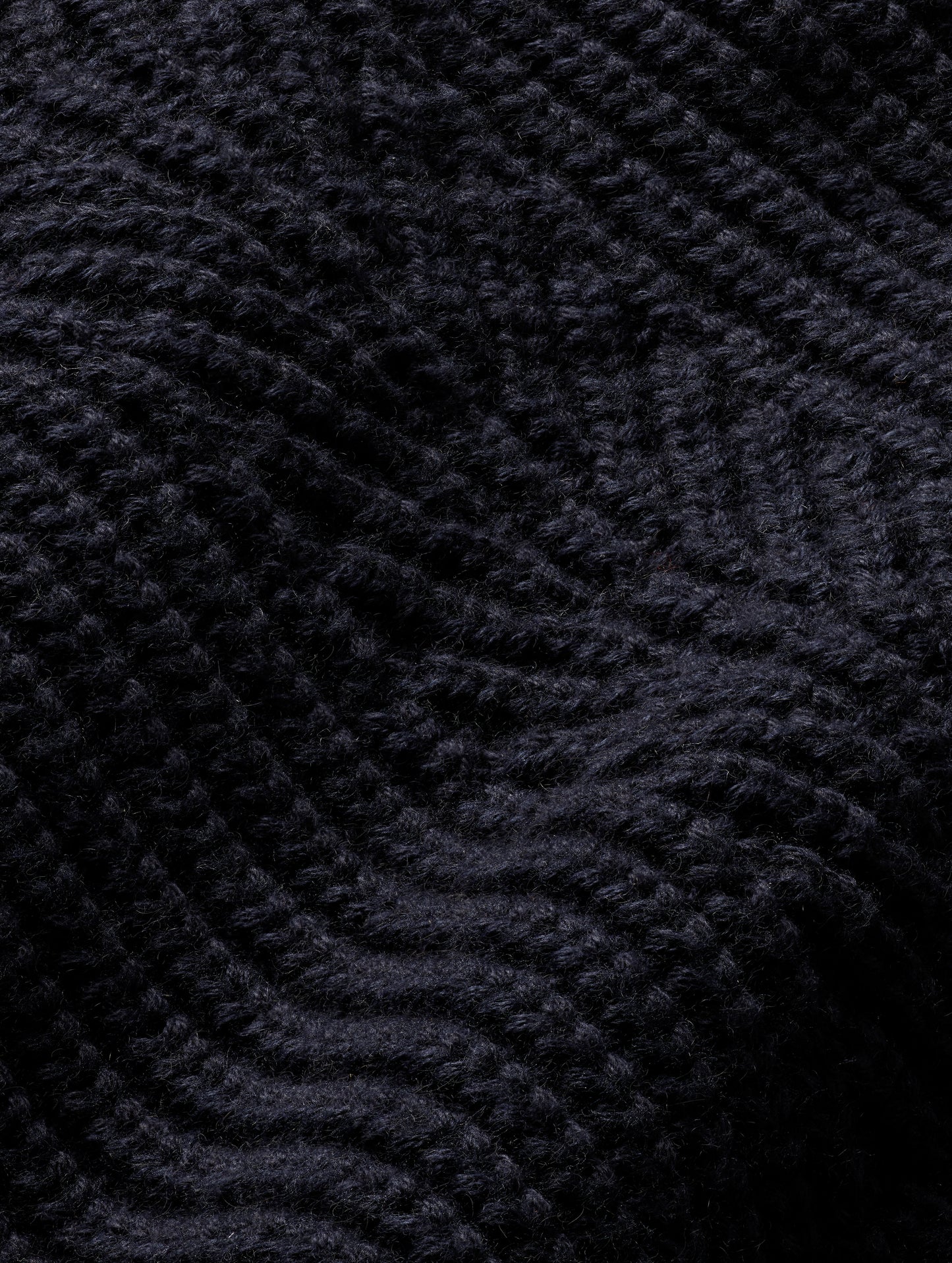 Closeup detailed view of ornate knitted construction of women's Cato Buttoned Sweater in Total Eclipse dark blue from AETHER Apparel.