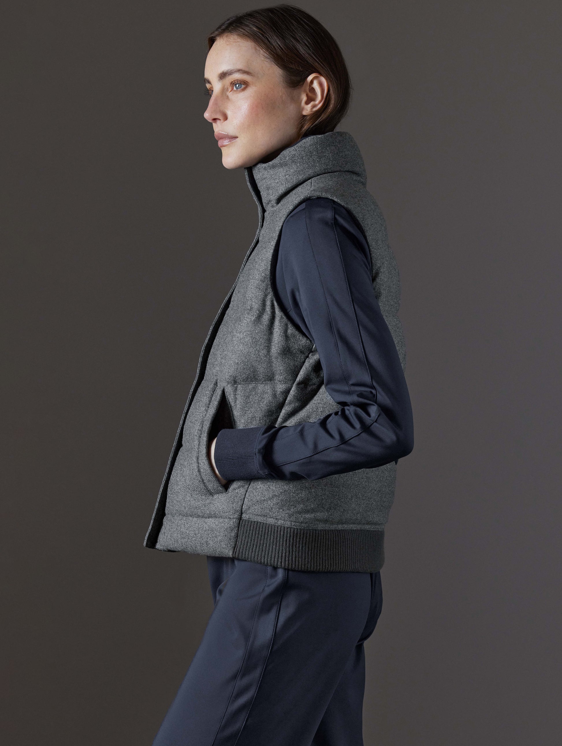 Side profile view of woman wearing Channing Vest 2.0 in Heather Grey from AETHER Apparel.