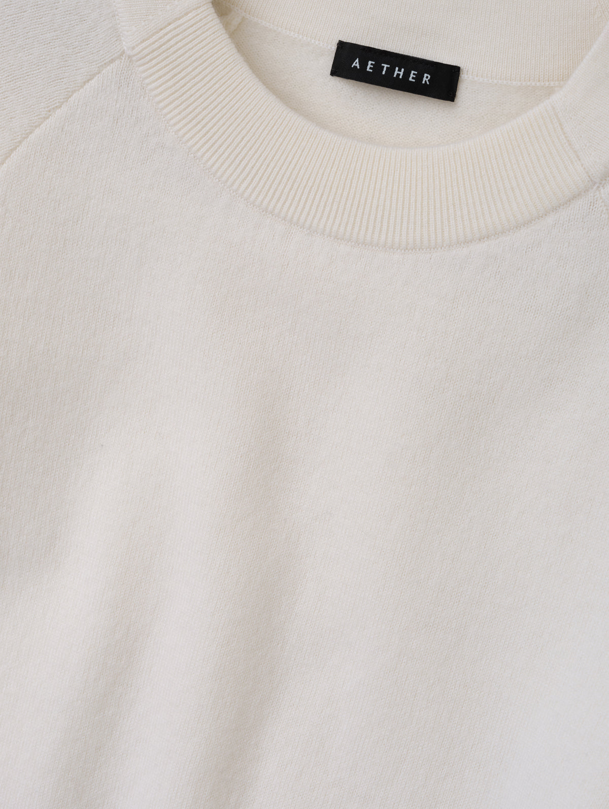 Closeup detailed view of the pieced in collar with rib knit front on the Dash Ombre Sweater in Winter White from AETHER Apparel.