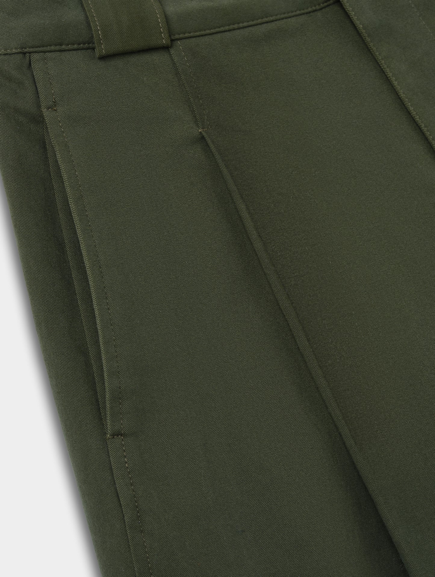 Closeup detailed view of the hand pockets and pleats on the Dune Short in Forest Green from AETHER Apparel.