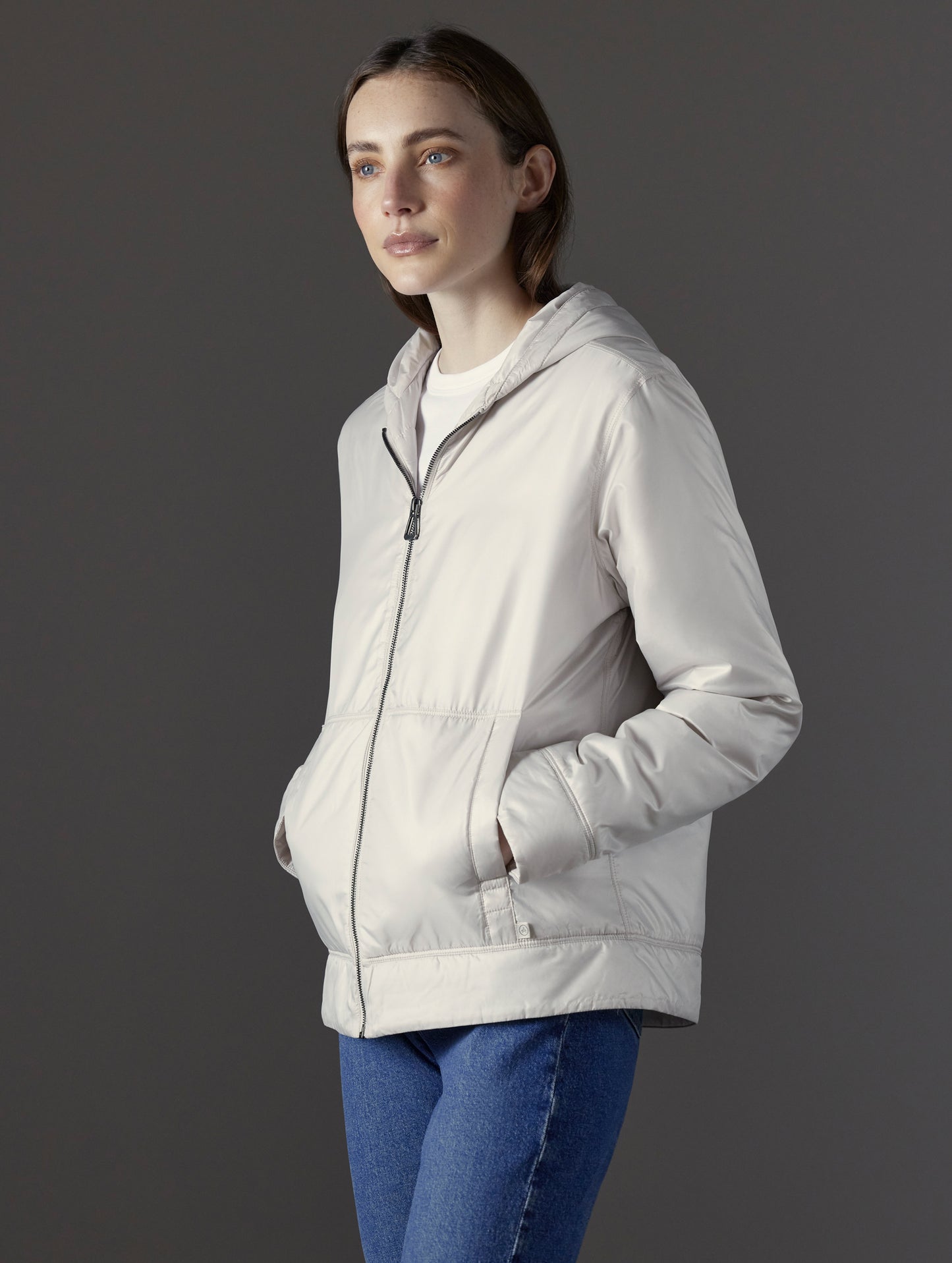 Front angled view of woman wearing Eco Space Hoodie in Bone white from AETHER Apparel.