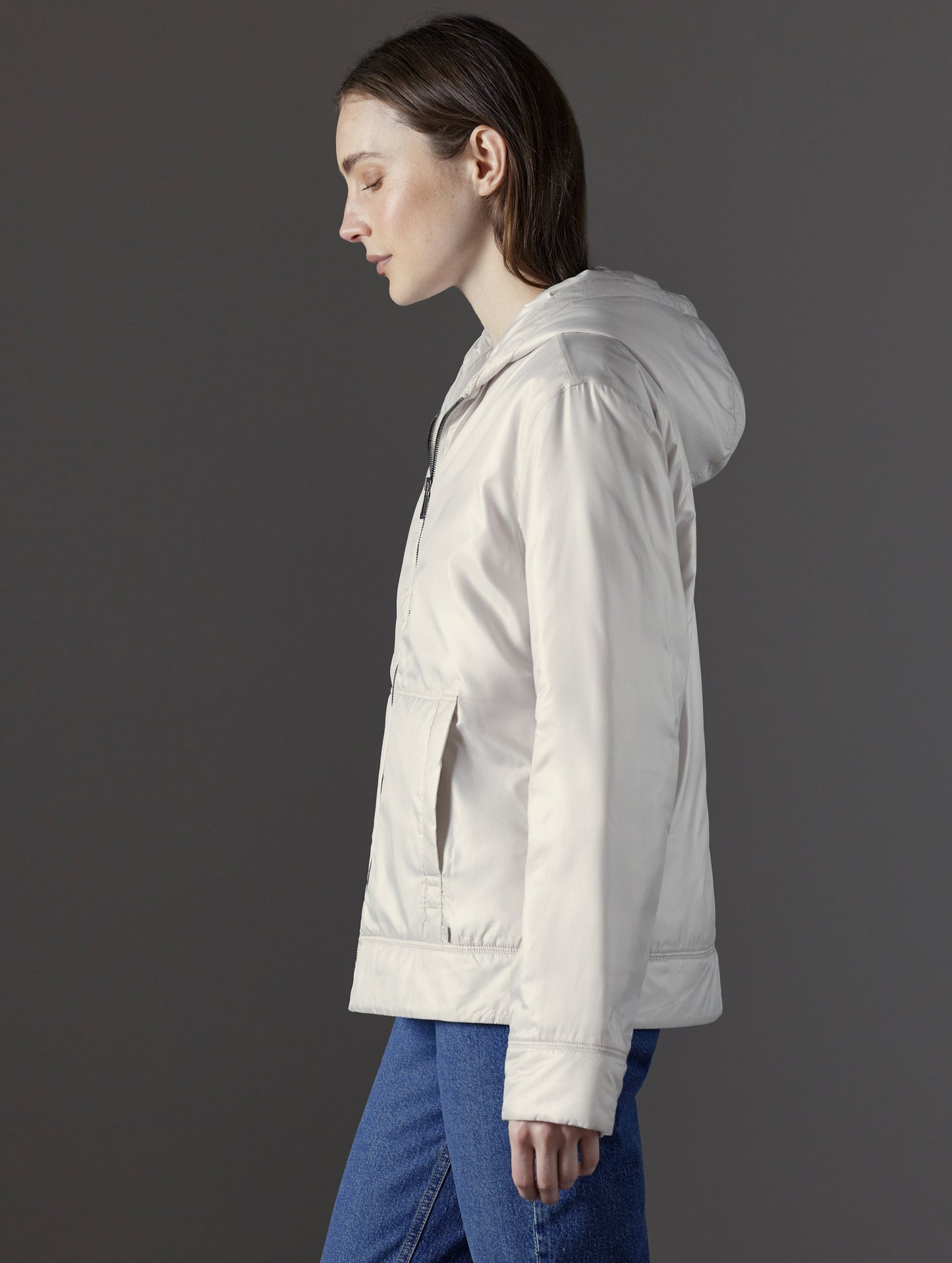 Side profile view of woman wearing Eco Space Hoodie in Bone white from AETHER Apparel.